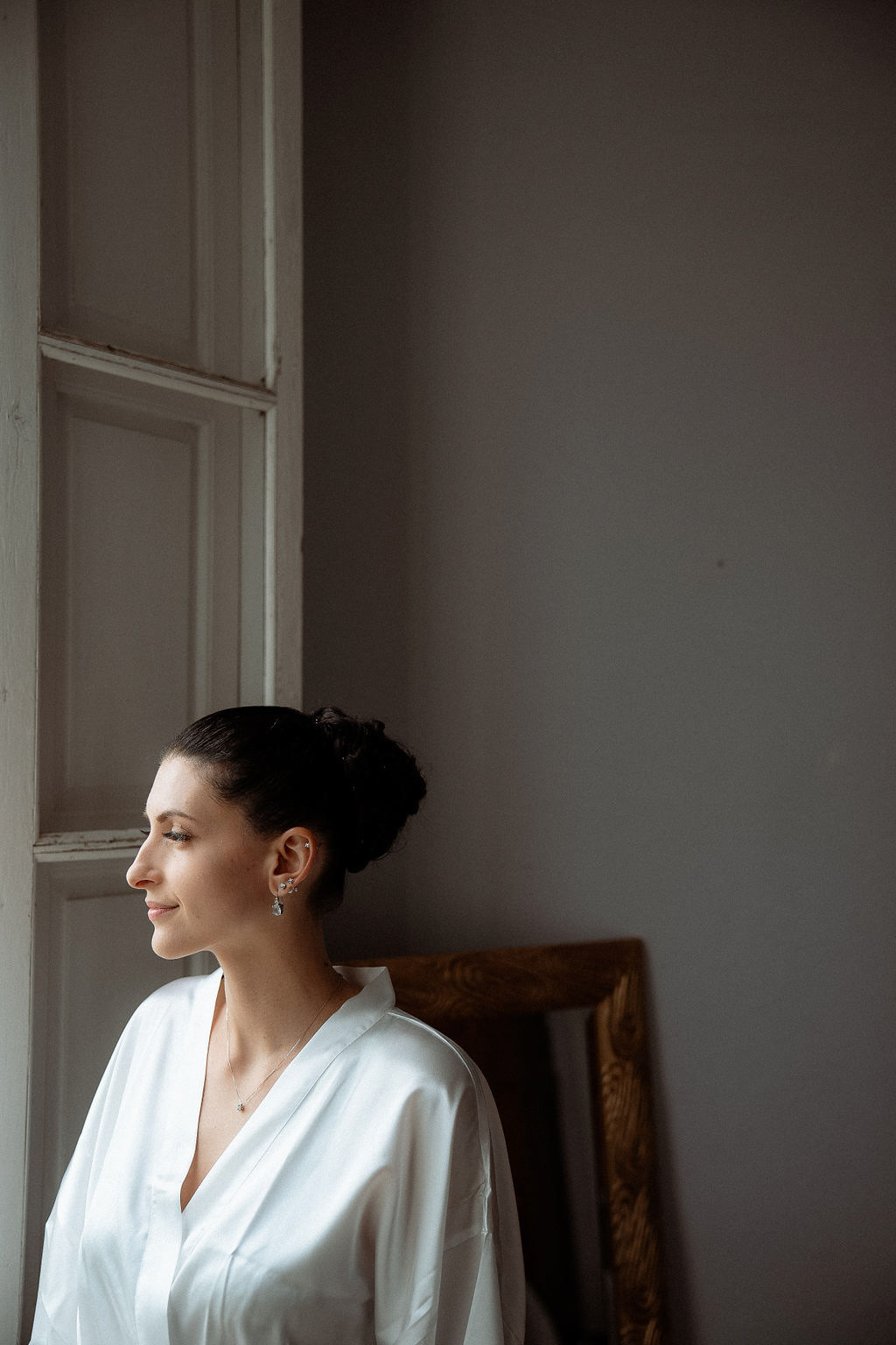Fotografia di Arianna Macherelli, specializzata in Fotografia di Matrimonio, ritratto di sposa di profilo mentre guarda fuori in attesa