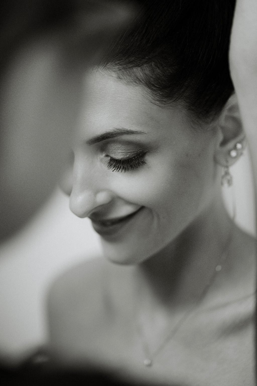 Fotografia di Arianna Macherelli, specializzata in Fotografia di Matrimonio, immagine rubata della sposa che sorride mentre le sistemano il velo