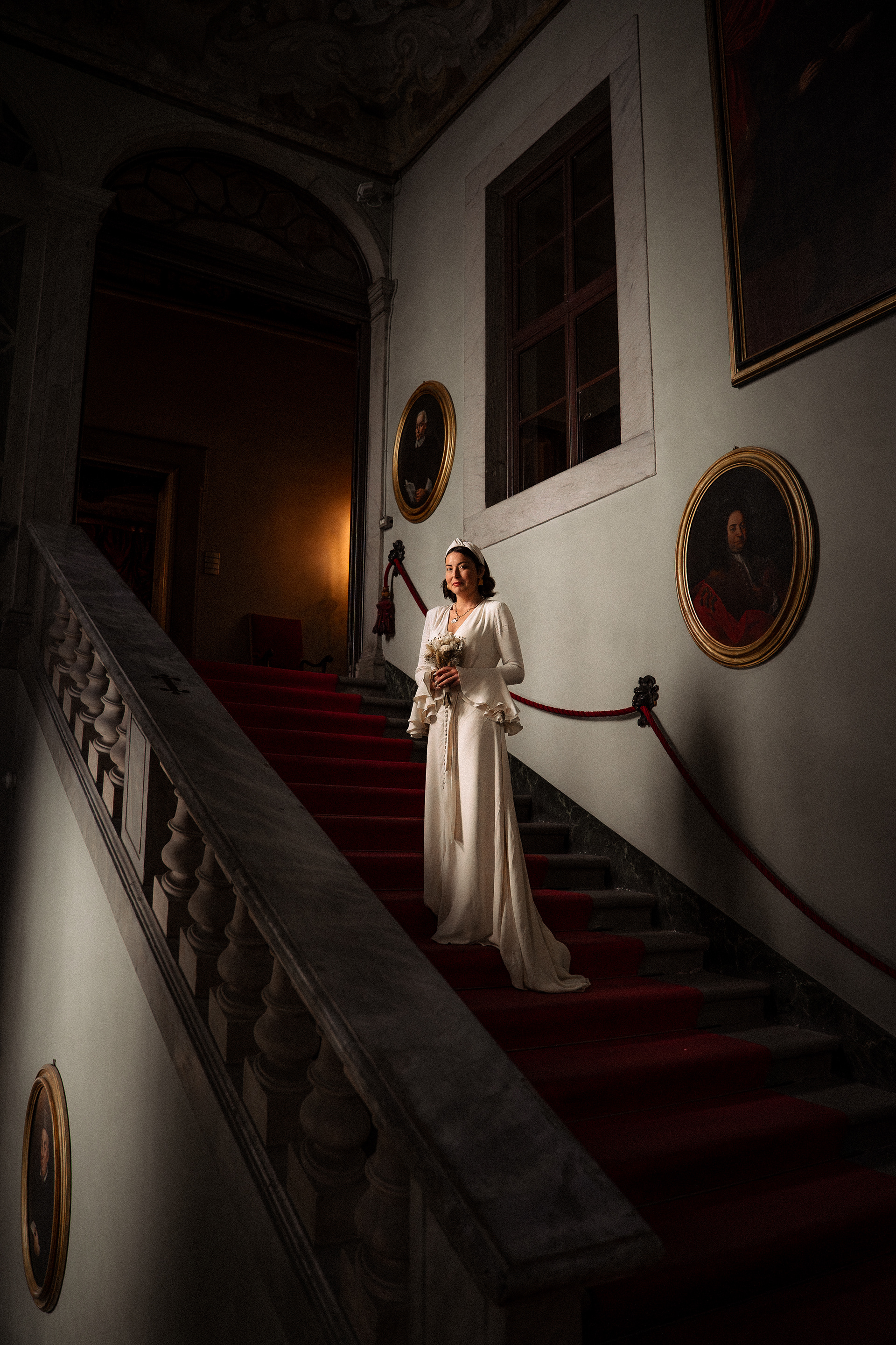 Fotografia di Arianna Macherelli, specializzata in Fotografia di Matrimonio, ritratto ambientato della Sposa con in mano il bouquet sulle scale