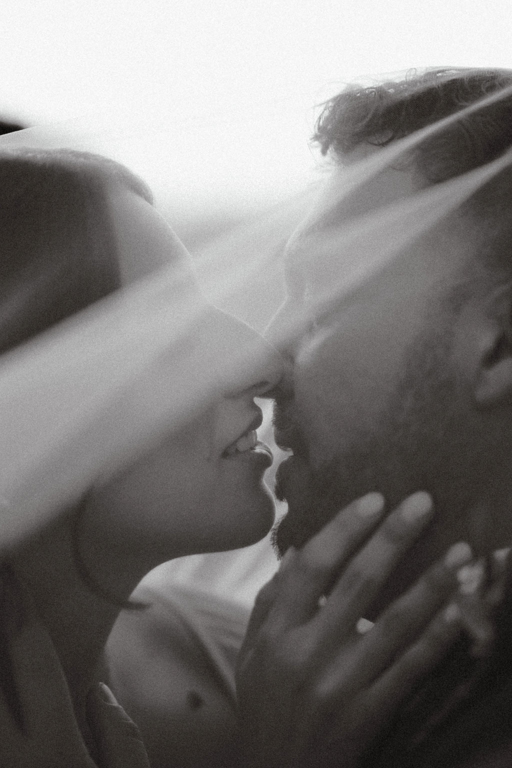 Fotografia di Arianna Macherelli, specializzata in Fotografia di Matrimonio, dettaglio in bianco nero del bacio degli sposi sotto il velo