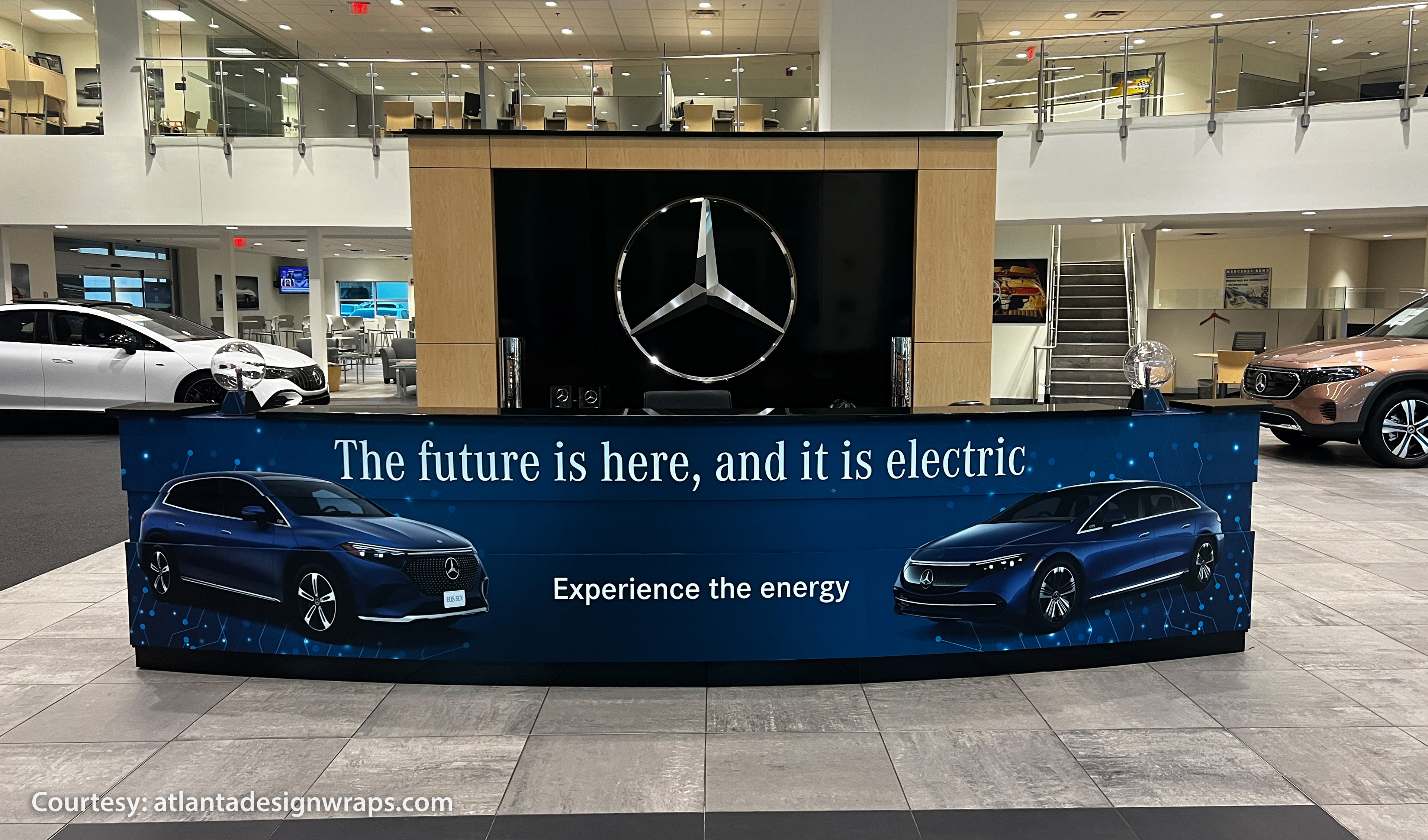 Electric vehicle graphics installed on the curved showroom counter at Mercedes-Benz of Buckhead