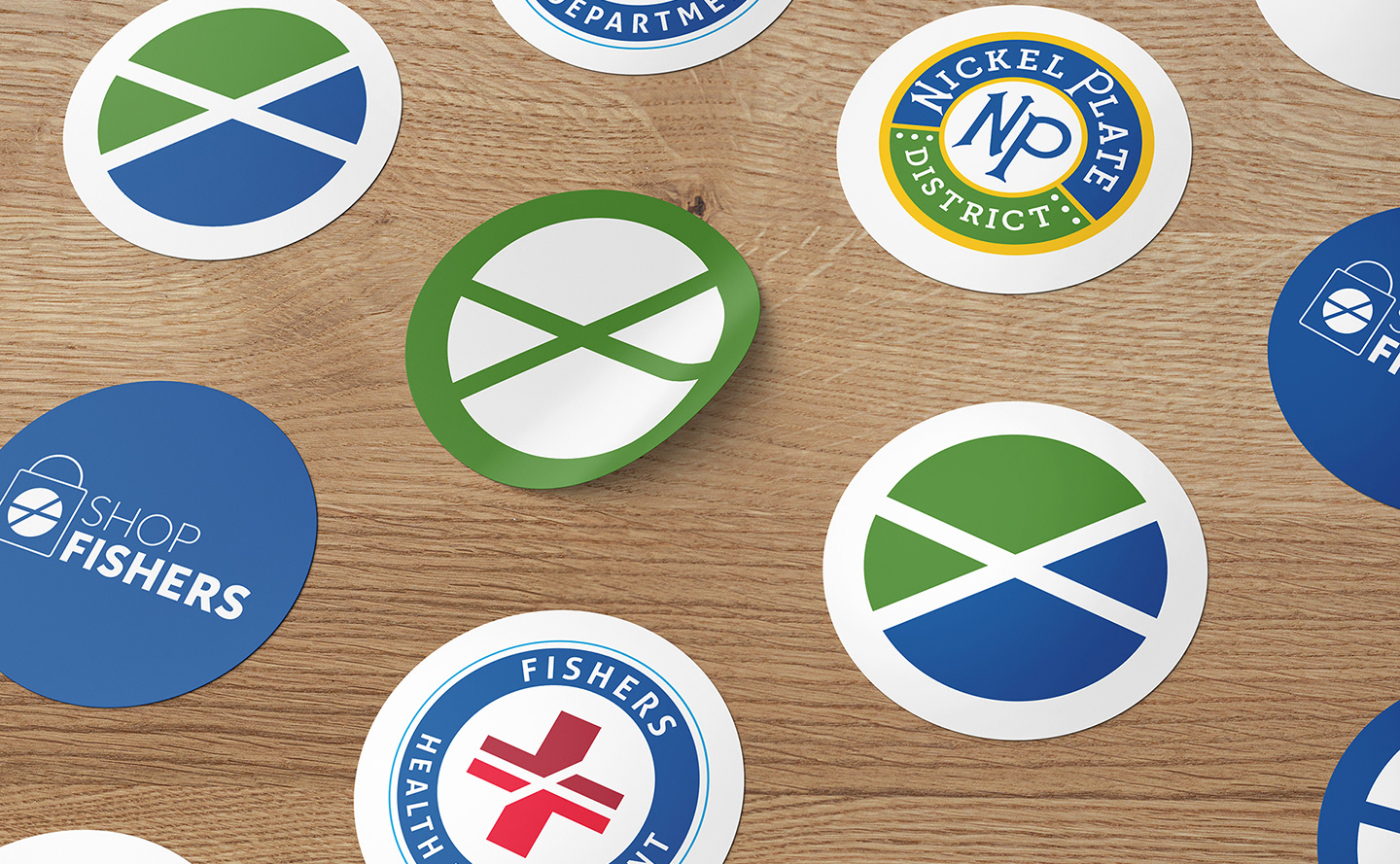 A collection of round stickers showcasing various logos for Fishers' brands, events, and initiatives