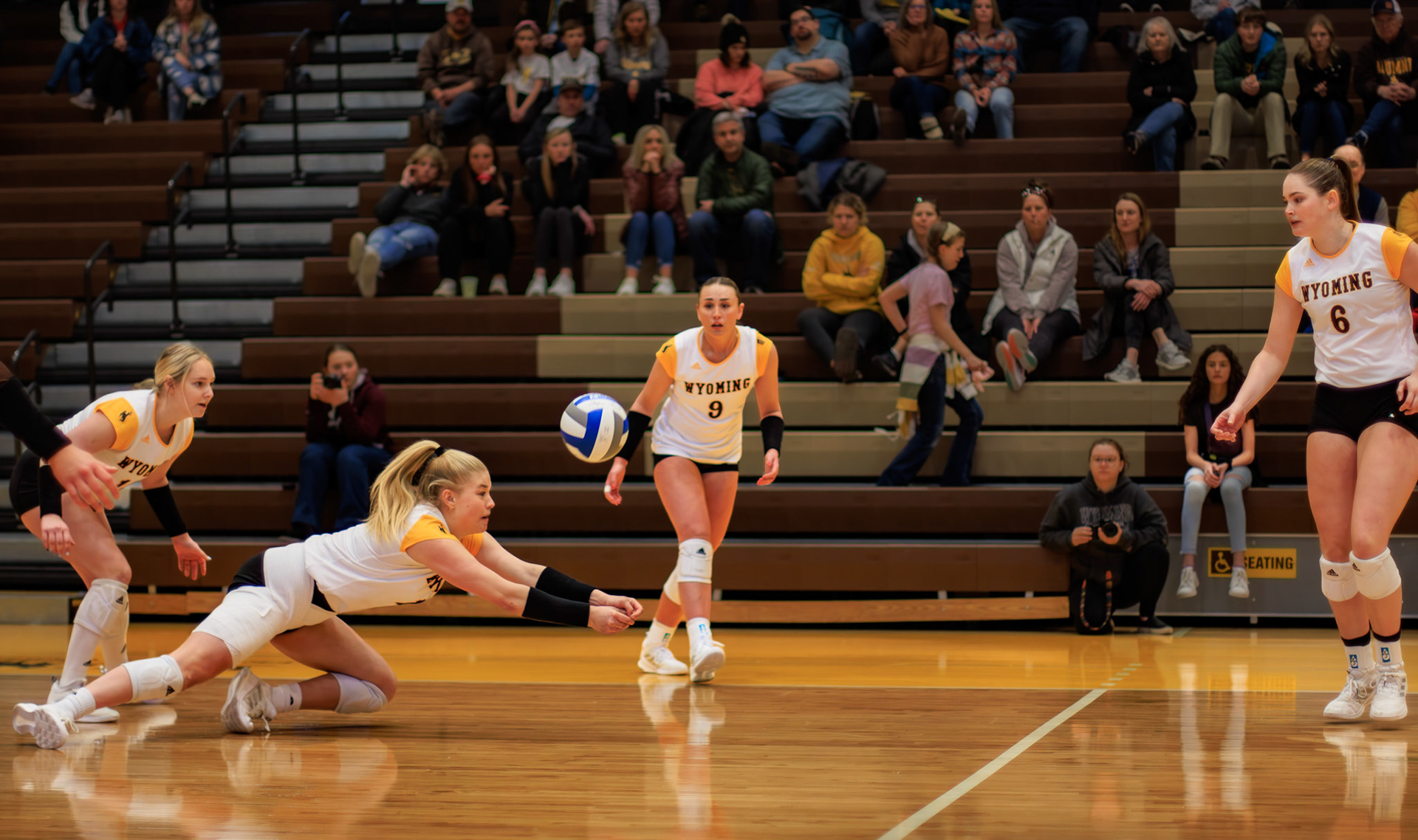 From left to right, Zoee Smith #15, Rylee Schulz #11, Corin Carruth #9, and Sara Holcomb #6 play a spring volleyball game against CU at the UniWyo Sports Complex in Laramie, Wyoming, on Saturday, April 15, 2023. Rylee Schulz #11 dives for the volleyball, while her teammates wait in anticipation to see where the ball will head.