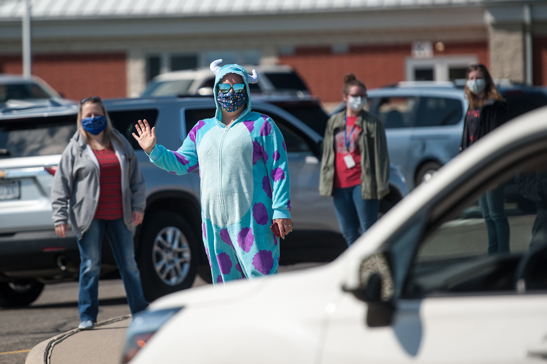 Helen Hassel waves at a vehicle during the lunch pickup at Fredericktown Elementary on April 27, 2020. Hassel and other school employees dressed in pajamas as part of Spirit Week in Ohio.