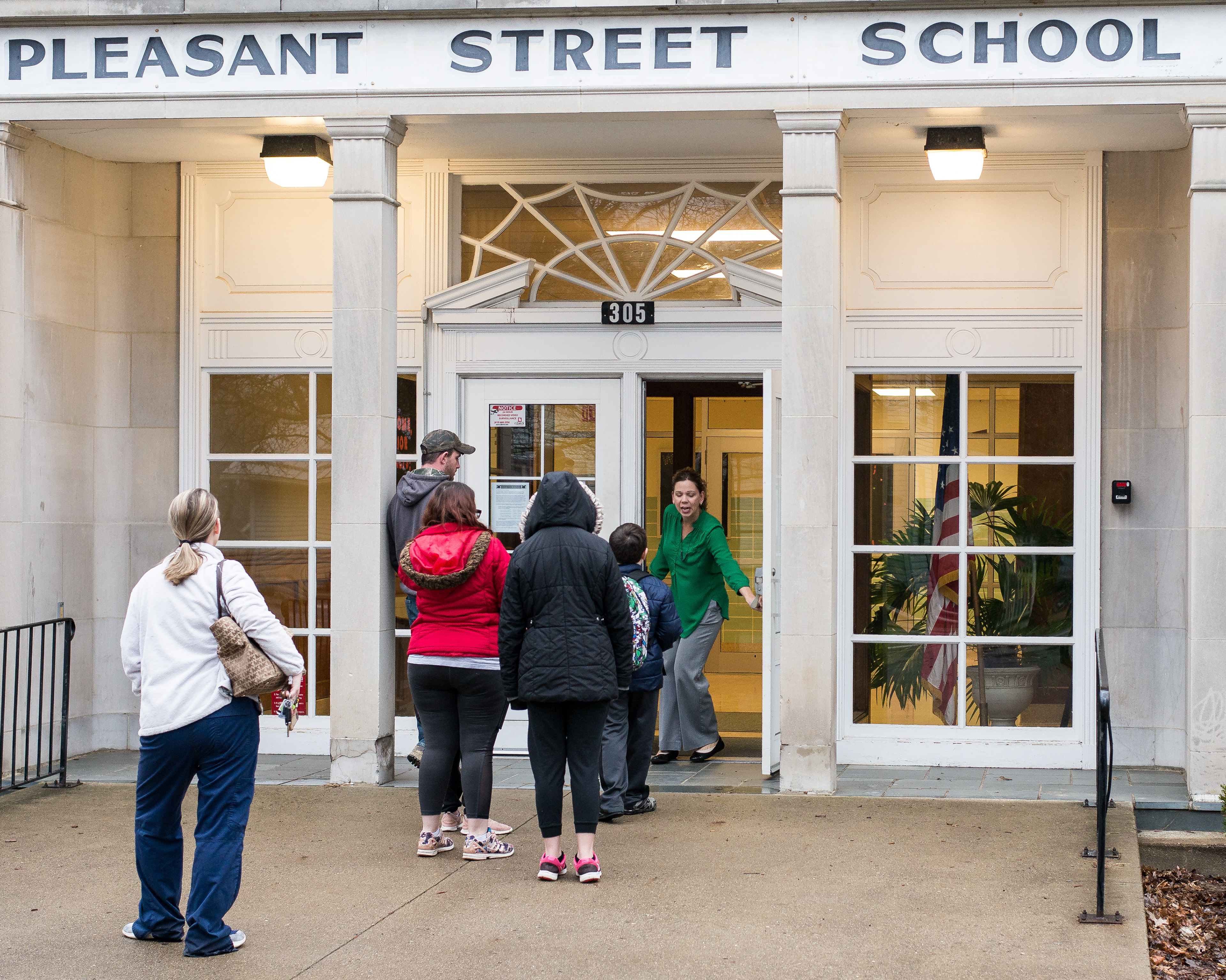 Parents and students are welcomed into Pleasant Street Elementary by Principal Teresa Weaver on March 18, 2020. Tuesday was the first day parents could pick up the school work required during the three-week closure.