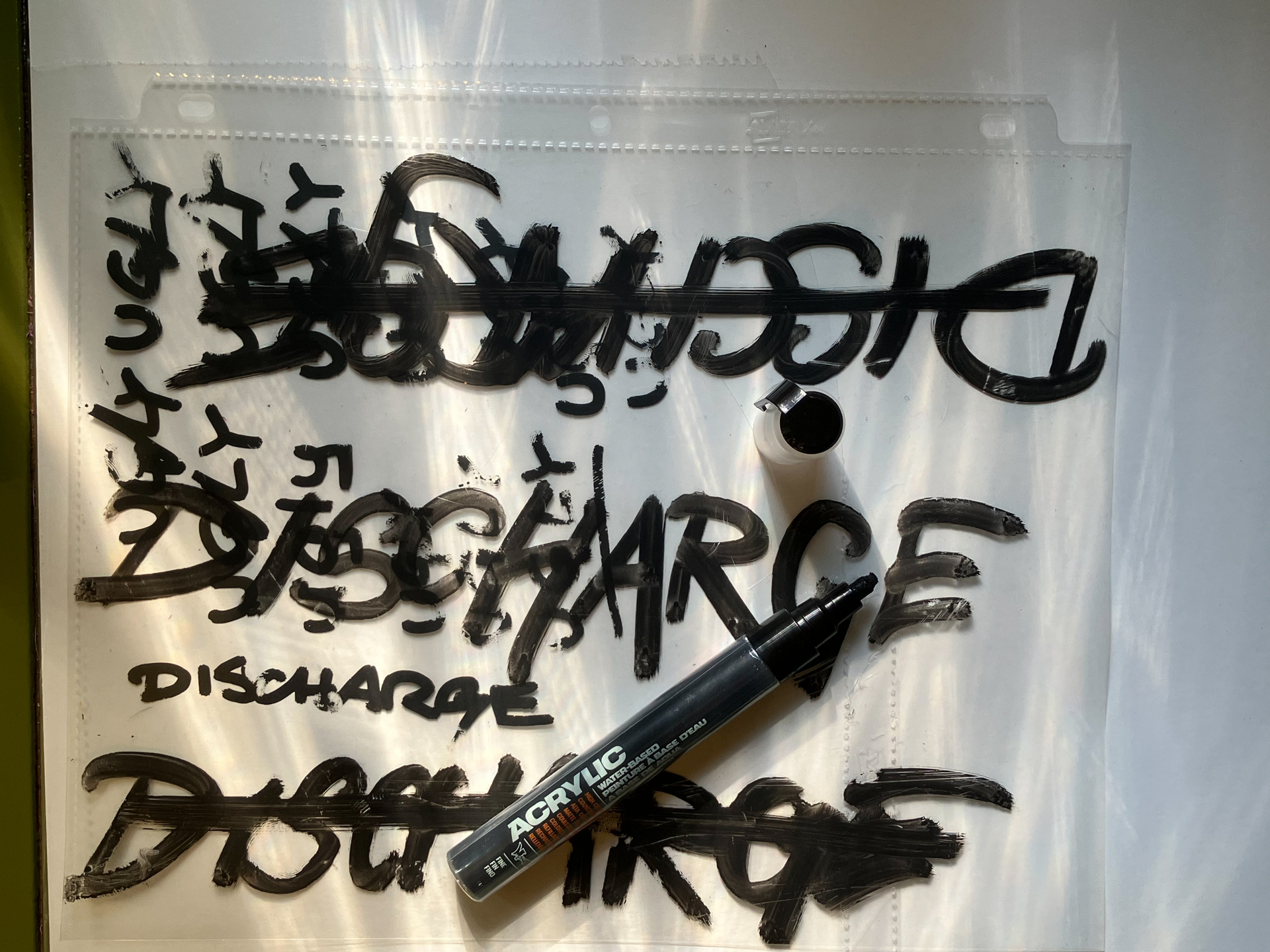 To reflect the fast and pissed nature of their music, and as a call back to the original, the "Discharge" type needed to be drippy, inky, and dirty. To create this, I used a paint pen on a clear sheet protector.