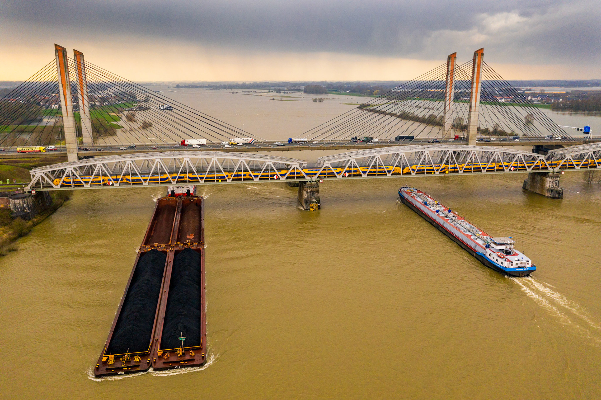Trein, schip en auto’s, alle vormen van mobiliteit, bij de Martinus Nijhoffbrug over de Waal bij Zaltbommel.