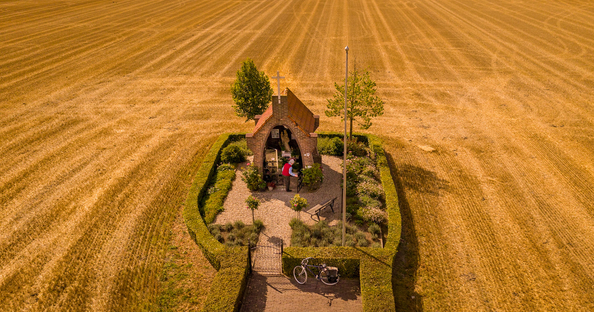 Chapel with old man in the middel of a grain field