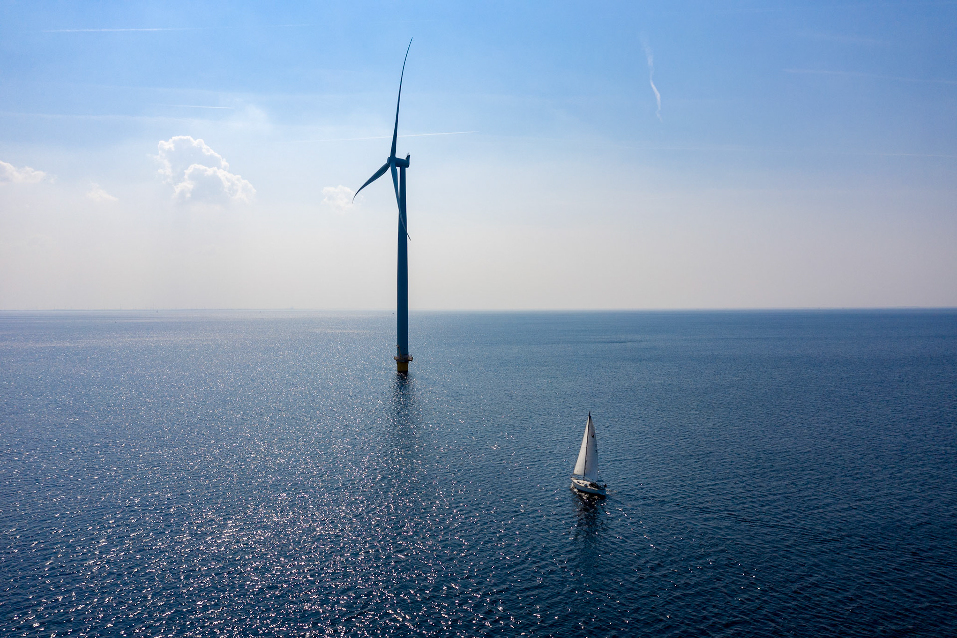 Windturbines met zeilboot in zee