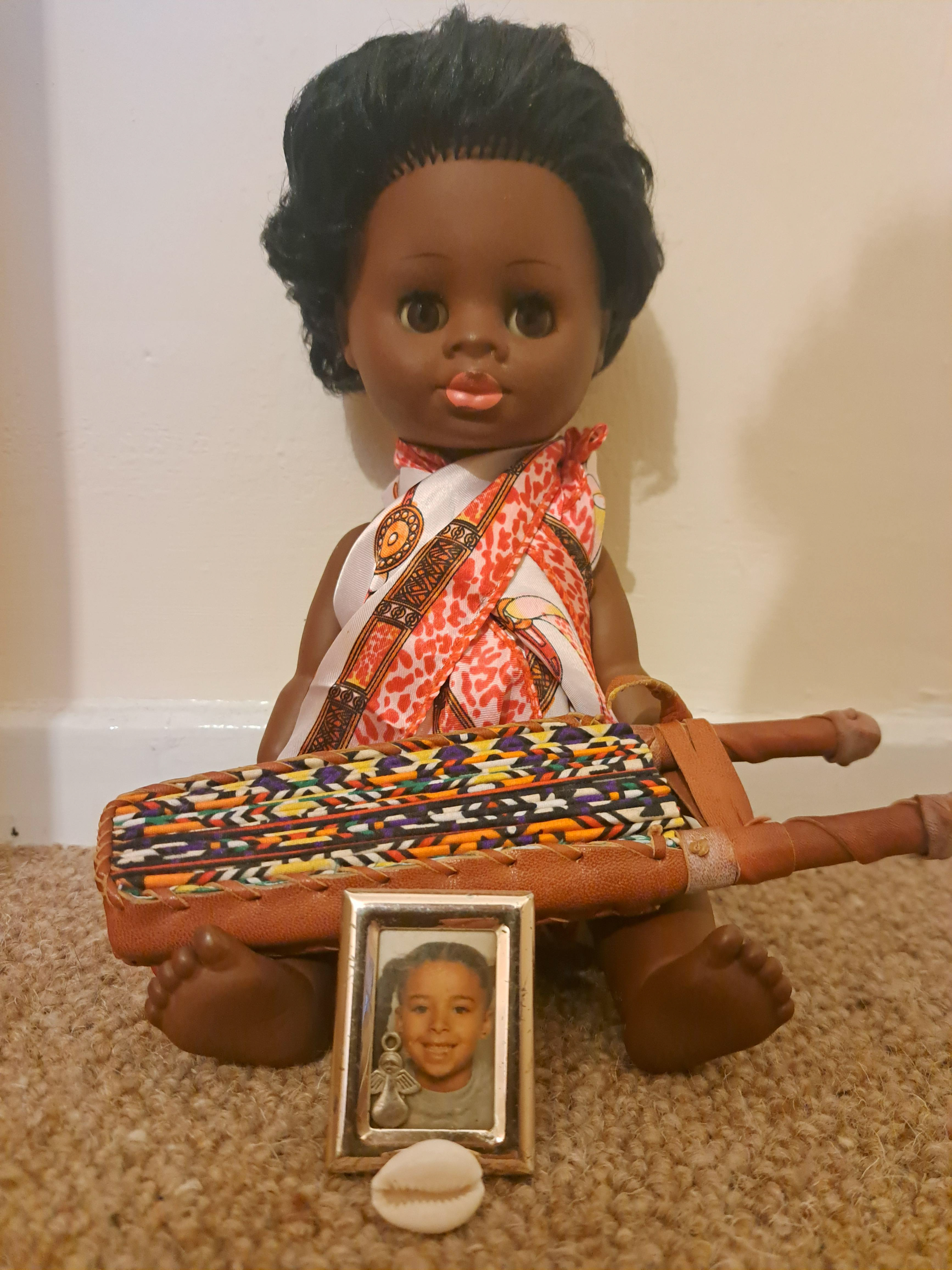 Lydia’s Object: “That was a doll that was my sister’s, and then it was mine. When I look at her, she seems like such a being, such an entity. I’ve got some shelves at home, and I’ve got her on there. It’s almost like a little shrine to her, because we lived in a really dysregulated household. It was really chaotic. I mean, it was a loving household and we were a close knit family. But I just think of what that doll’s seen, sat there innocently. And it’s almost like she carries all that. One of my first ideas for a poem was talking about things through her eyes. I used a tiny picture of myself as well and a little cowrie bead to represent the ancestry. She’s a baby doll but to me she seems like a woman.” Credit: Lydia Williams