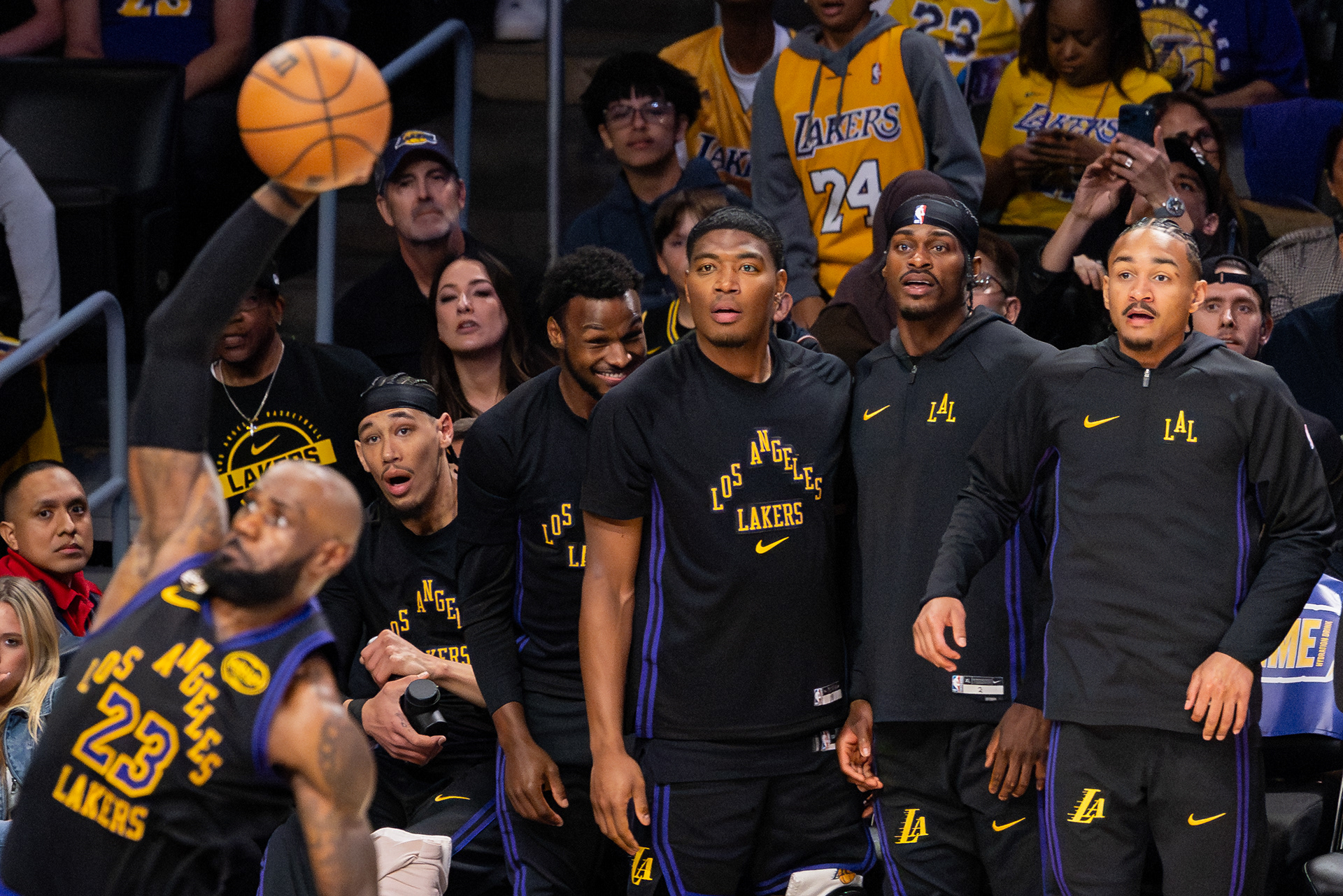 The Los Angeles Lakers bench looks on as LeBron James dunks the ball at Crypto.com Arena in Los Angeles, CA