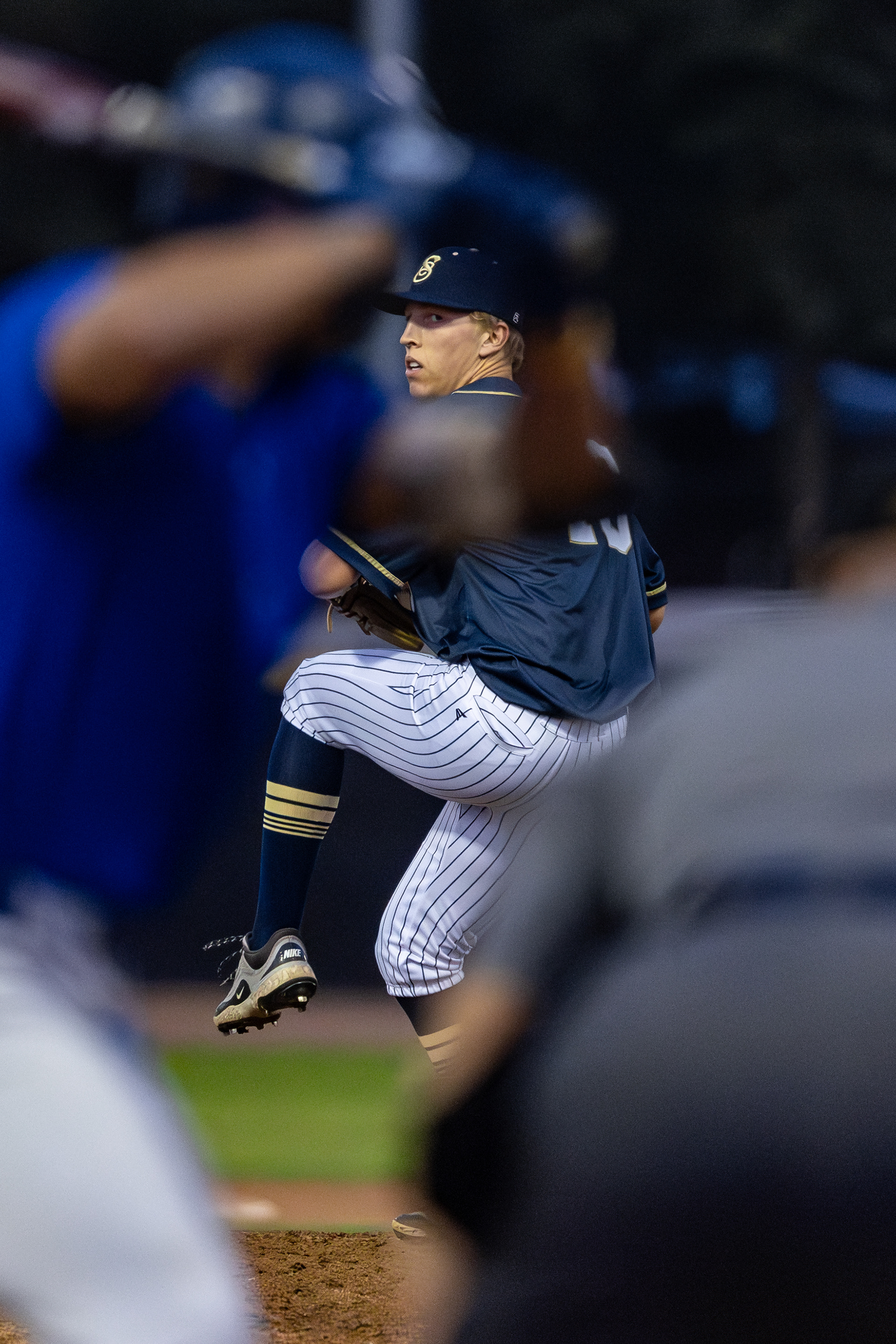 College baseball pitcher prepares to deliver a pitch in a California Collegiate Baseball League baseball game at Jackie Robinson Field in Pasadena, CA