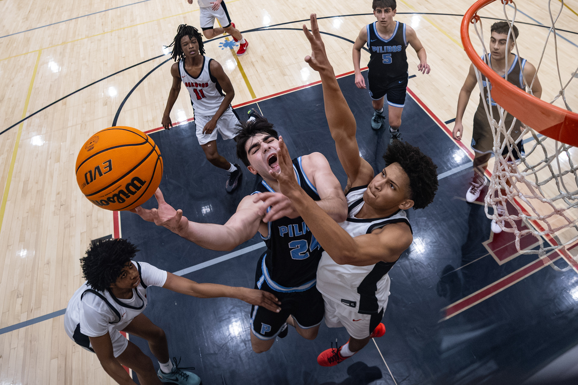 Pilibos player drives to the rim against Oakwood during a high school basketball game.