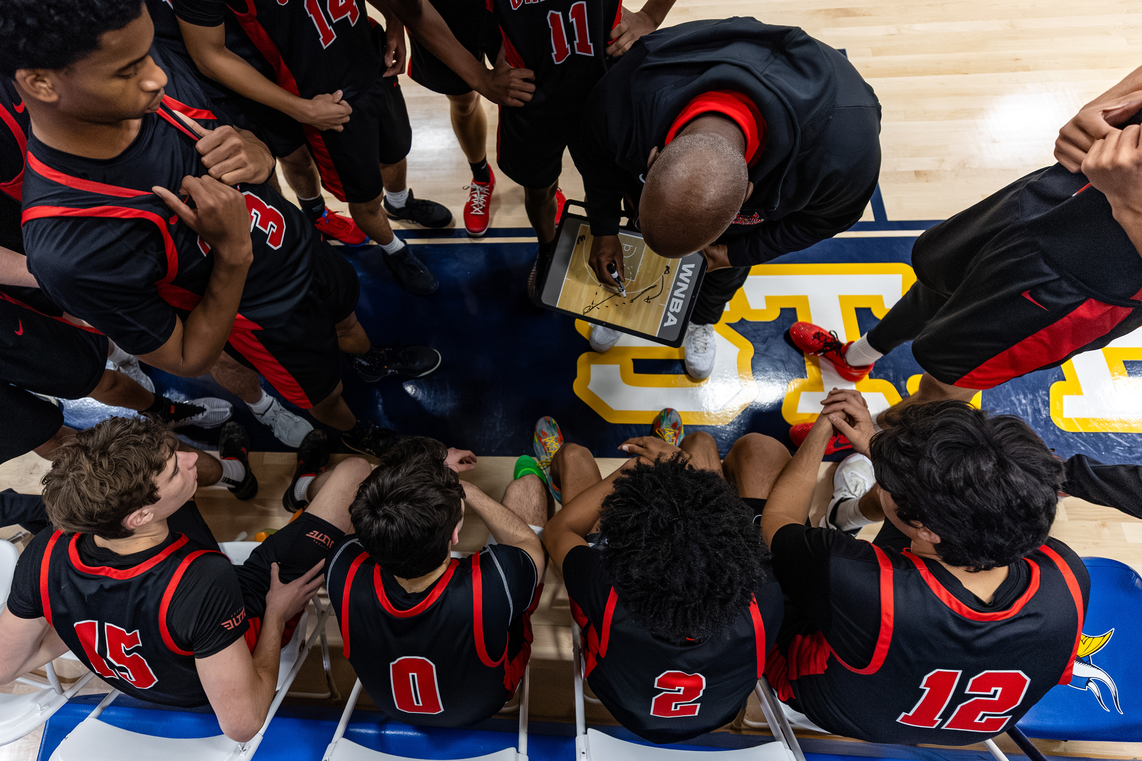 Oakwood players in a huddle with head coach Steve Smith during a CIF Southern Section High School Boys Varsity Basketball game in Playa Del Rey, CA