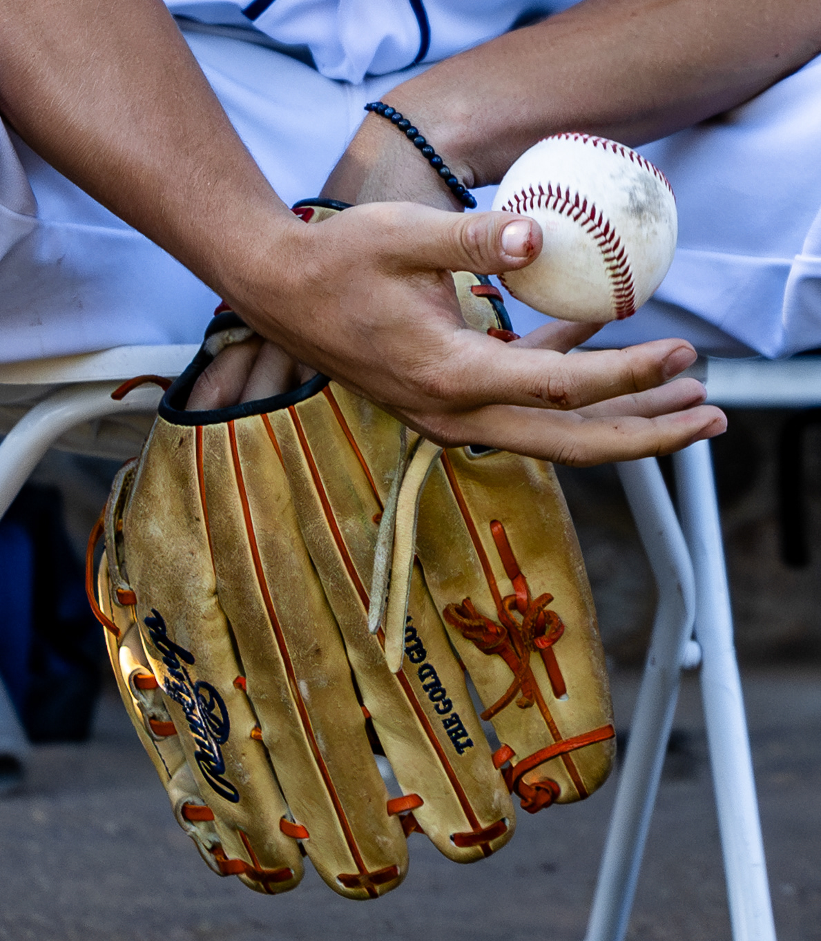 College baseball player tosses a ball in the dugout during a California Collegiate Baseball League Game at Jackie Robinson Stadium in Pasadena, CA