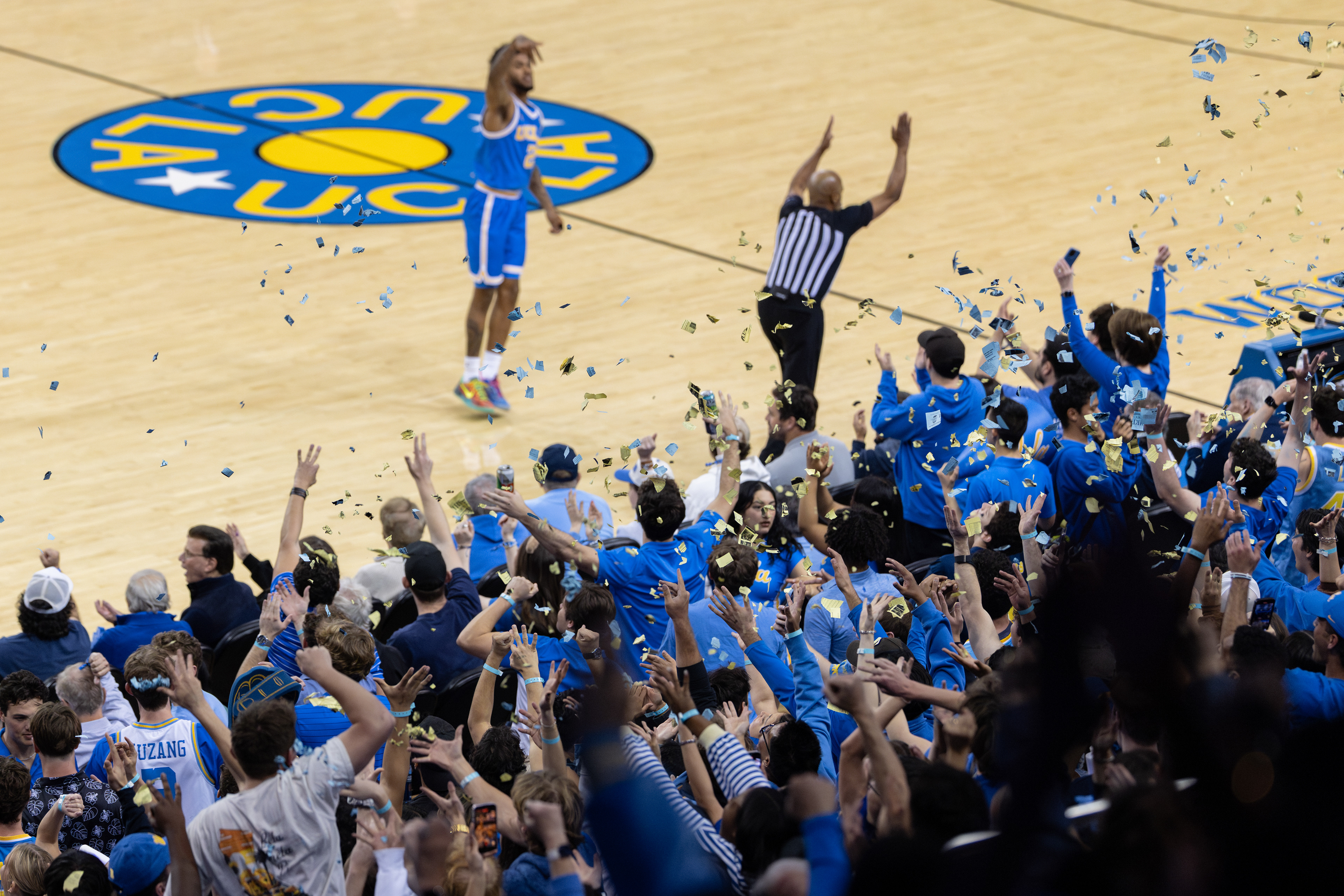 UCLA students celebrate a three point shot by UCLA guard Donovan Dent during an NCAA basketball game at Pauley Pavilion in Los Angeles, CA