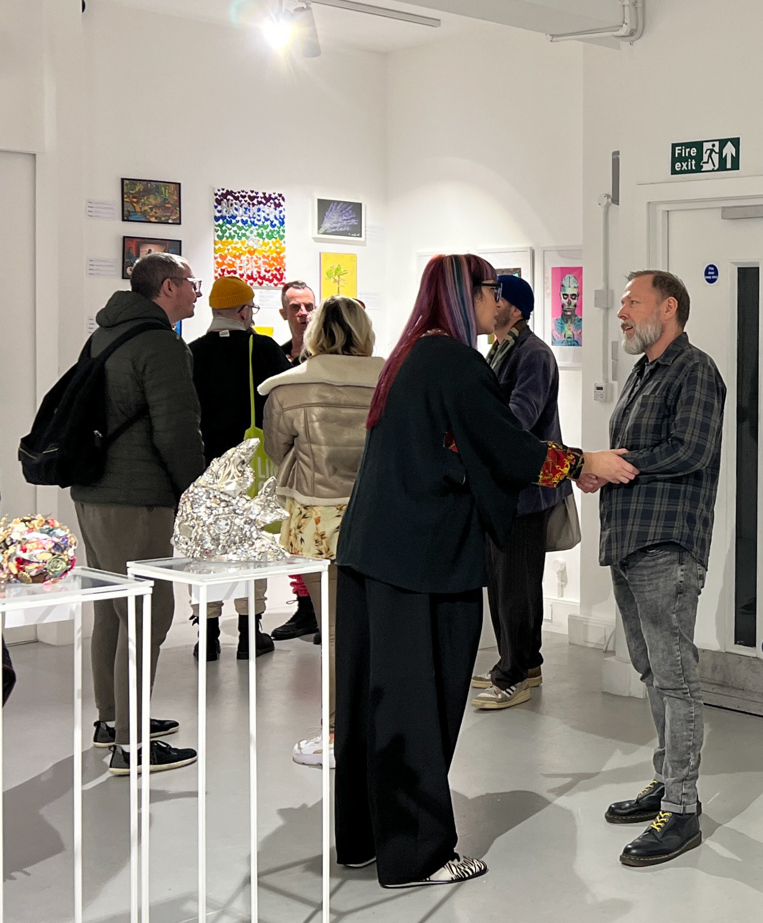 Founder Danny Good and Artist Leigh-Anna Barber connecting at the Clear Canvas  Vol. 1 Exhibition with visitors viewing artwork behind them