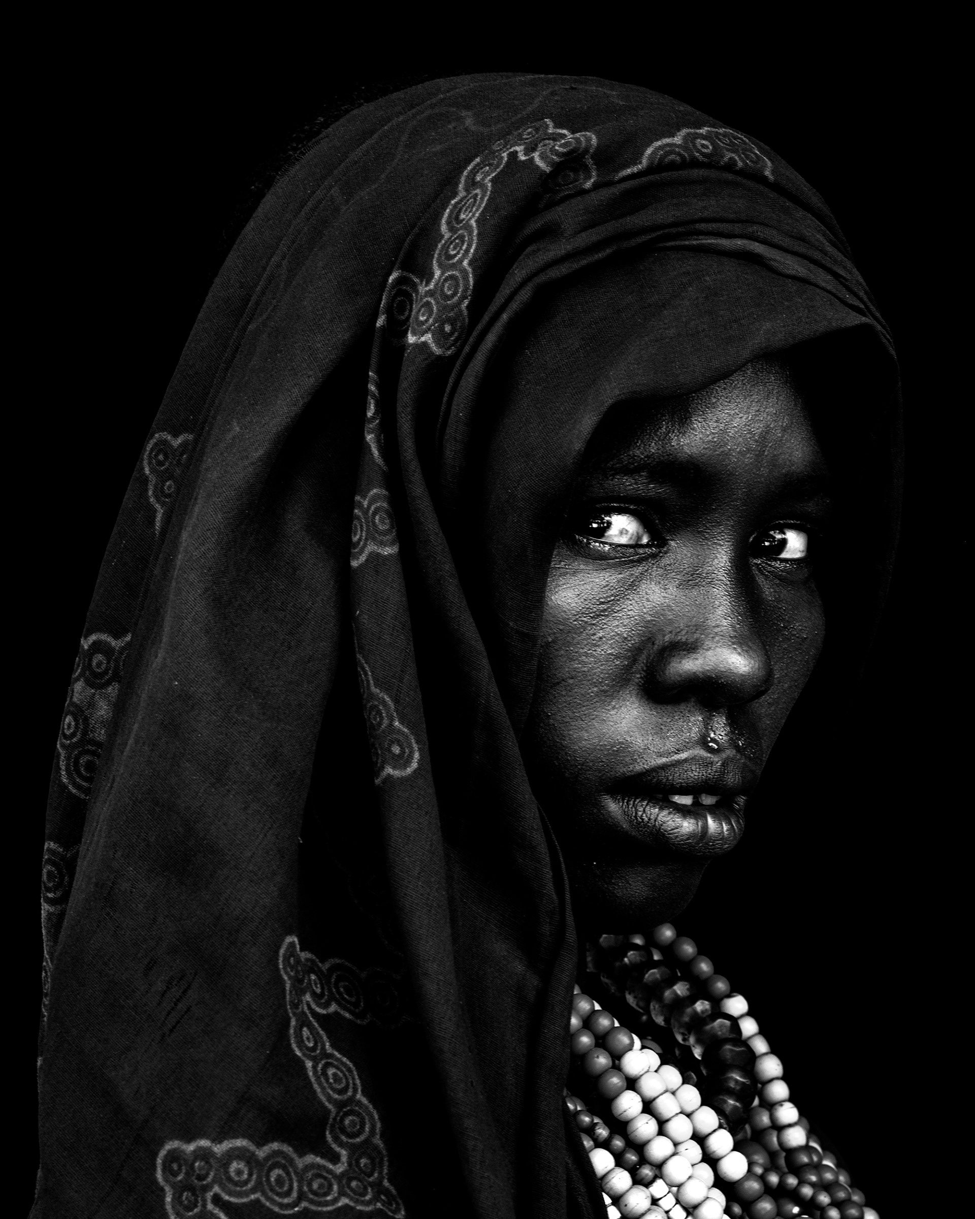 Black and white portrait of a woman from the Arbore community wearing traditional adornments, Lower Omo Valley, Ethiopia, 2025.