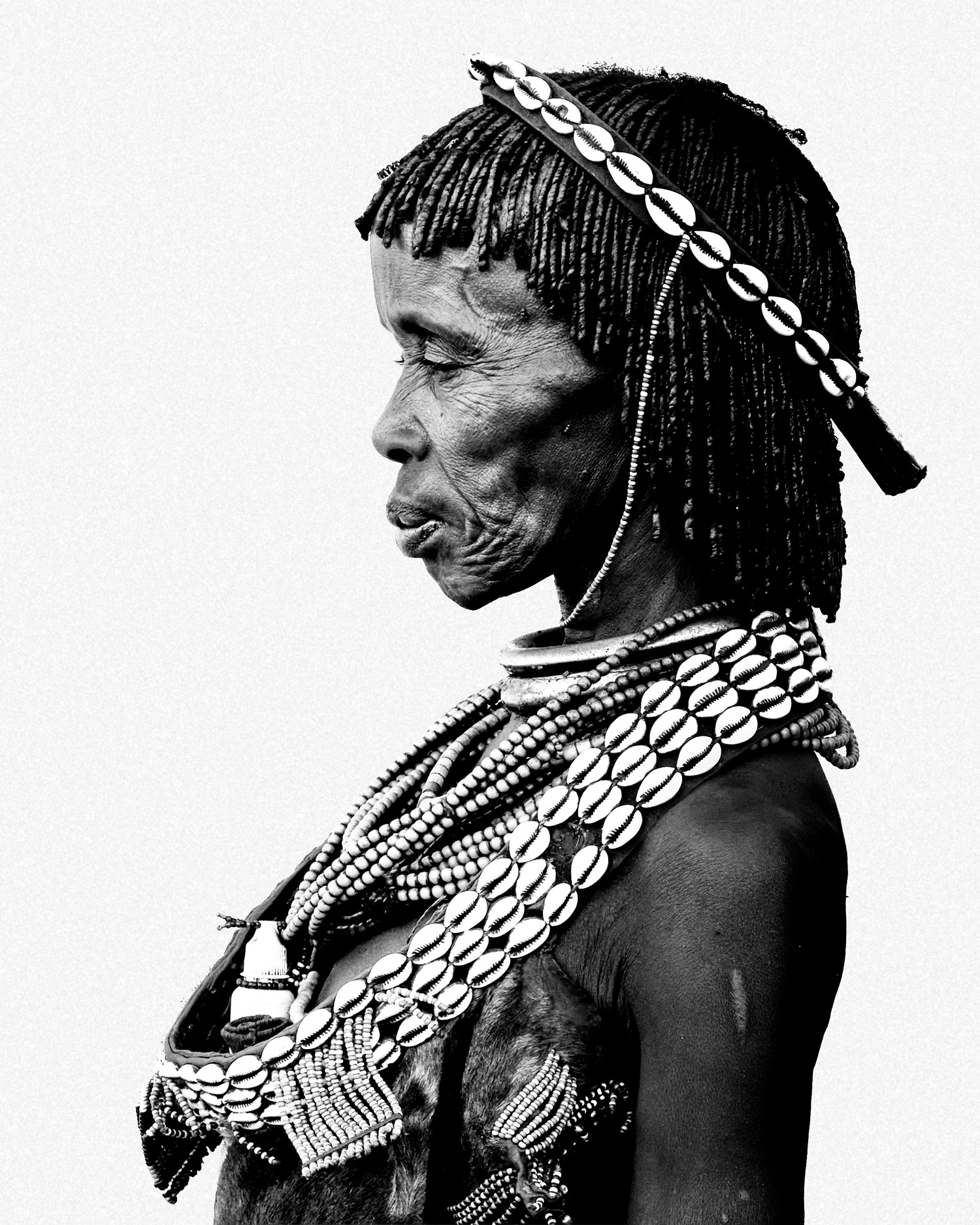 Black and white profile portrait of a woman from the Hamer community wearing traditional adornments, Lower Omo Valley, Ethiopia, 2025.