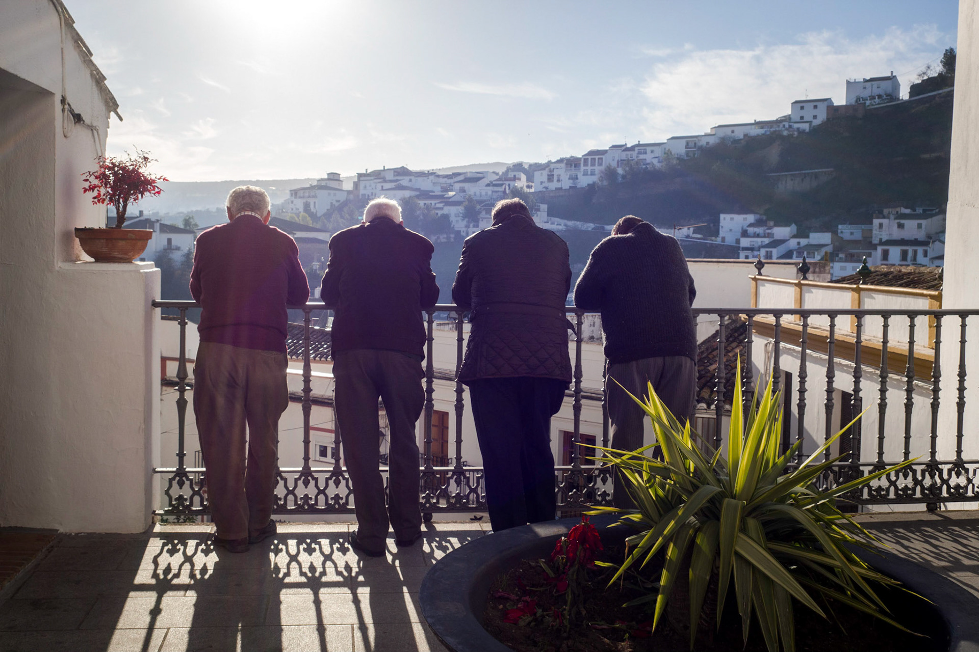 These four men enjoy a splendid view of a traditional Andalucian whitewashed village, Setenil De La Bodegas, Spain.