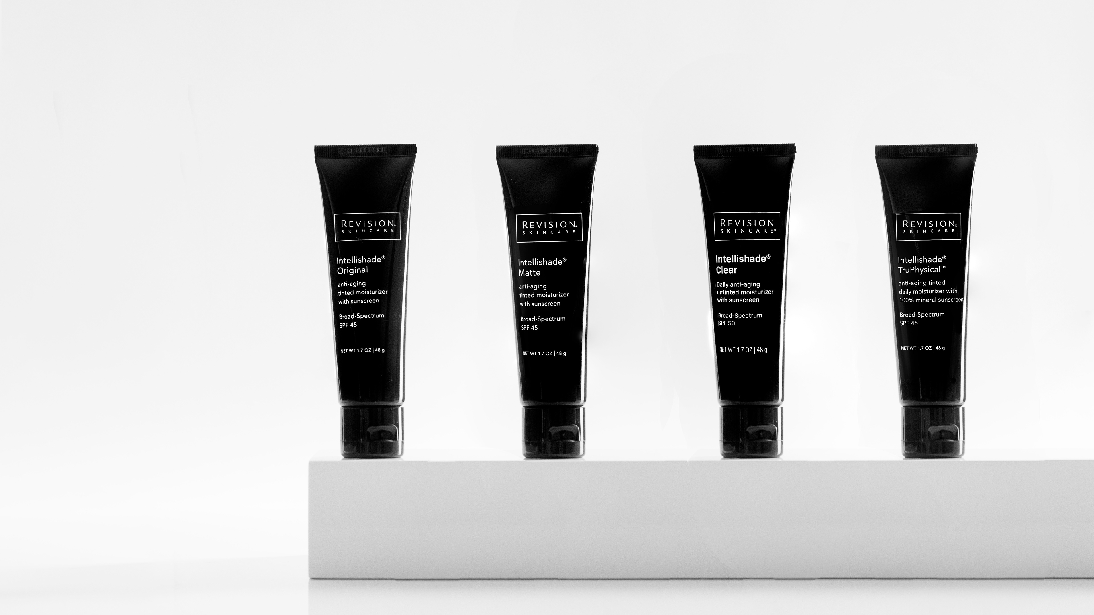 Black and white hero image of Revision Skincare's line of Intellishade facial SPF