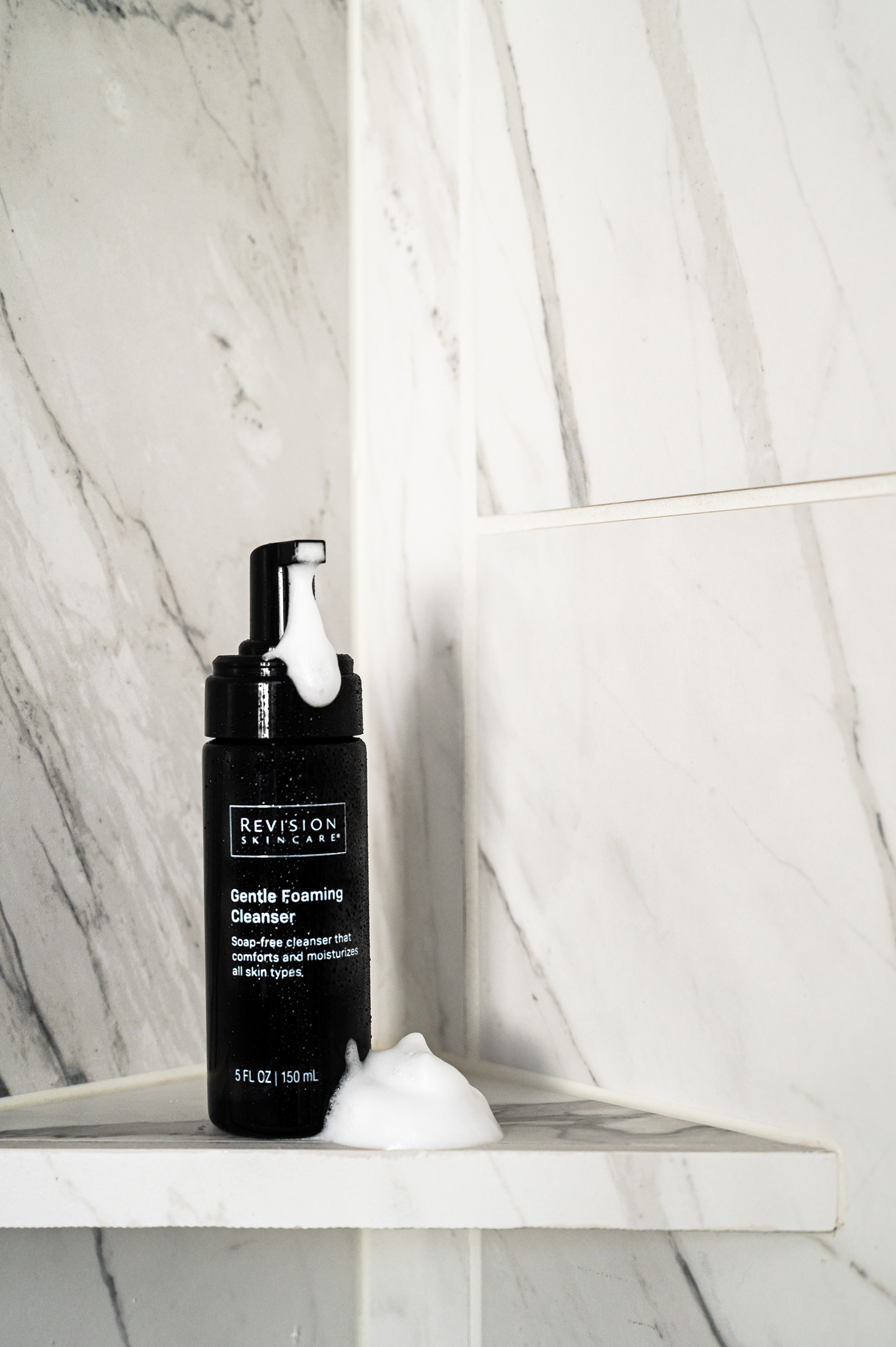 Revision Skincare Gentle foaming Cleanser styled on a shower shelf