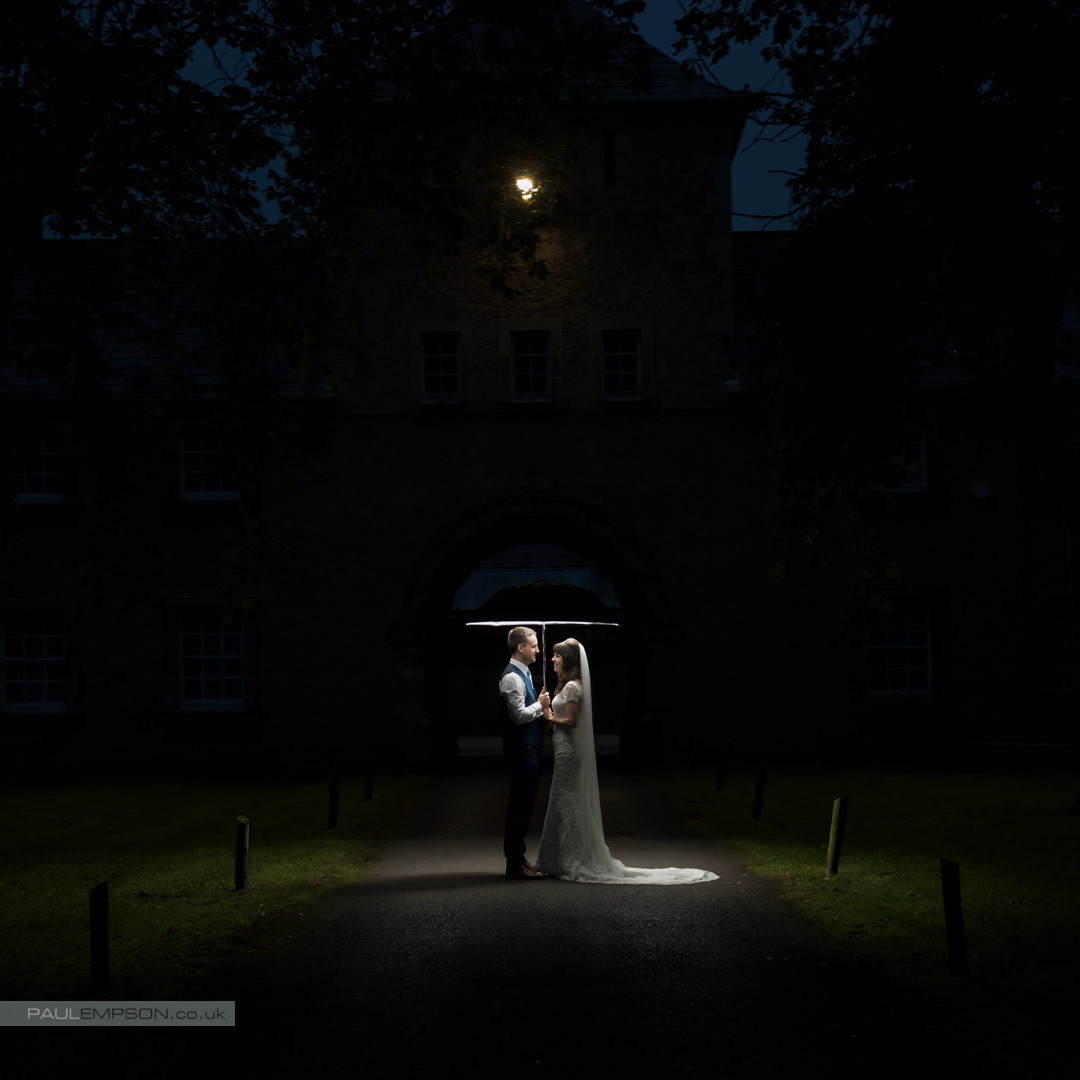Crathorne Hall wedding bride & groom together at night under an umbrella