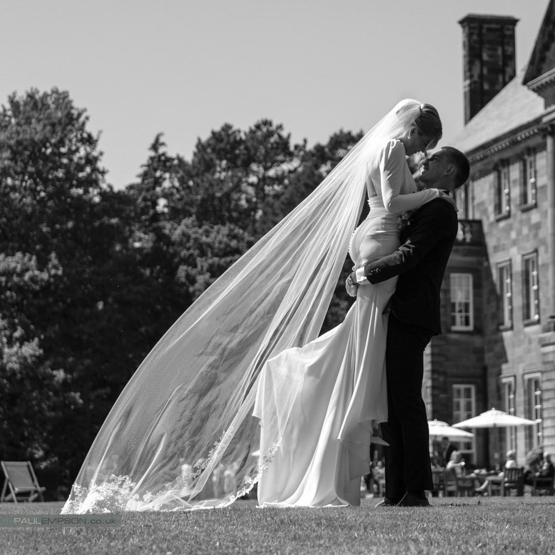 Crathorne Hall summer wedding groom lifts his bride in the air on the lawns