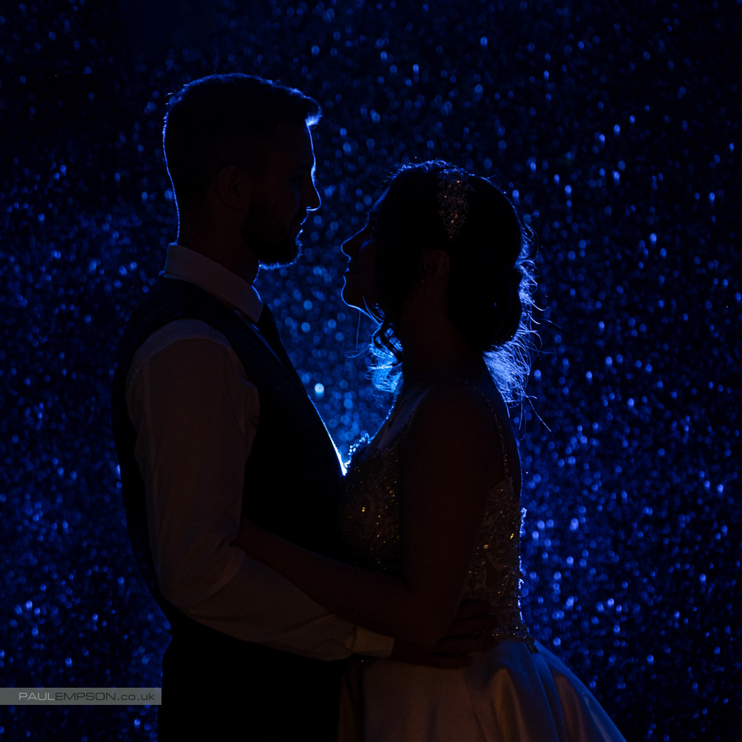 Whinstone View wedding, bride & groom silhouetted against the raindrops at night
