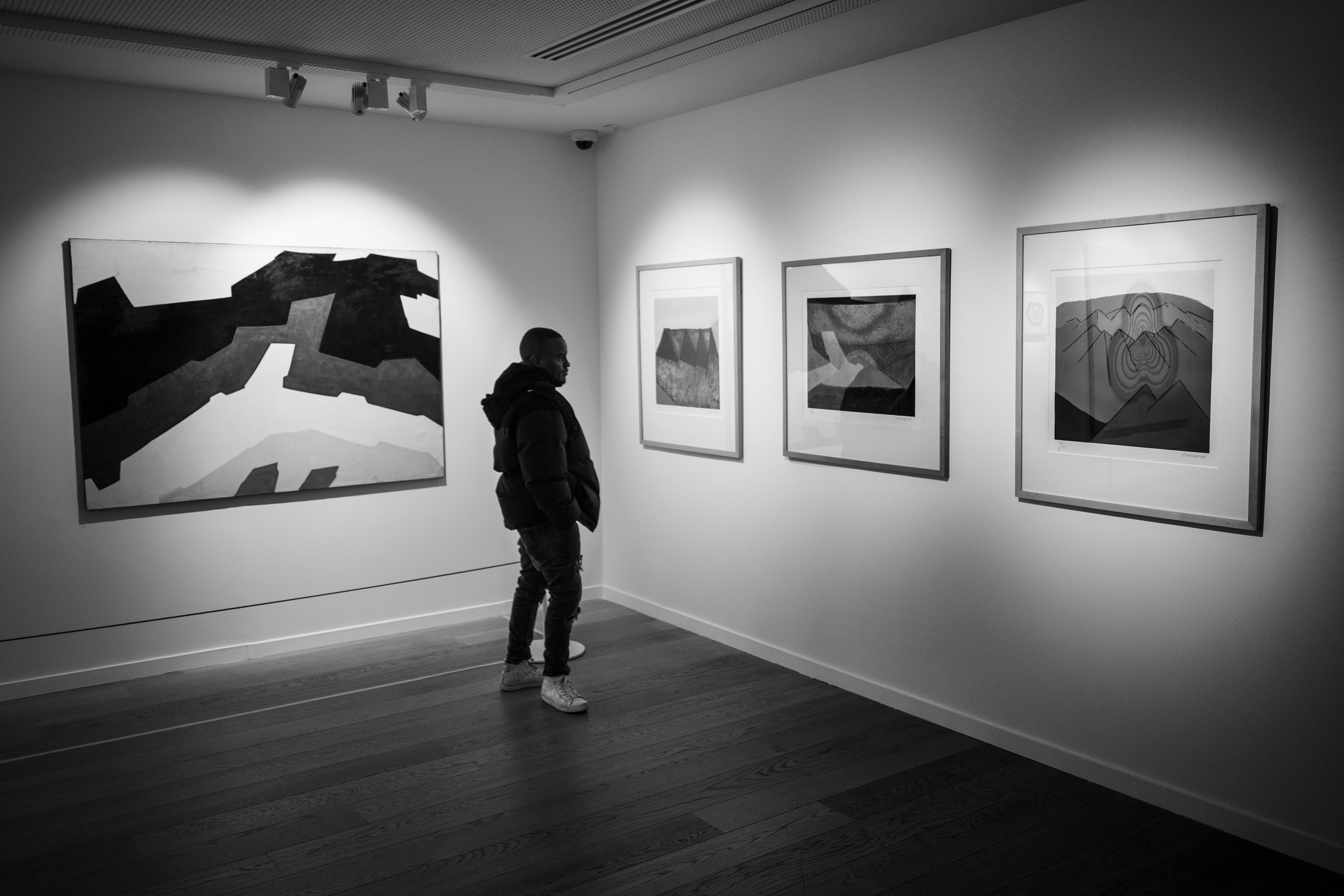Abdulnasser, a student at the École des Cuistots Migrateurs, looks at paintings during a cultural outing to the Korean Institute on 3 February 2026 in Paris (2nd arrondissement), France.