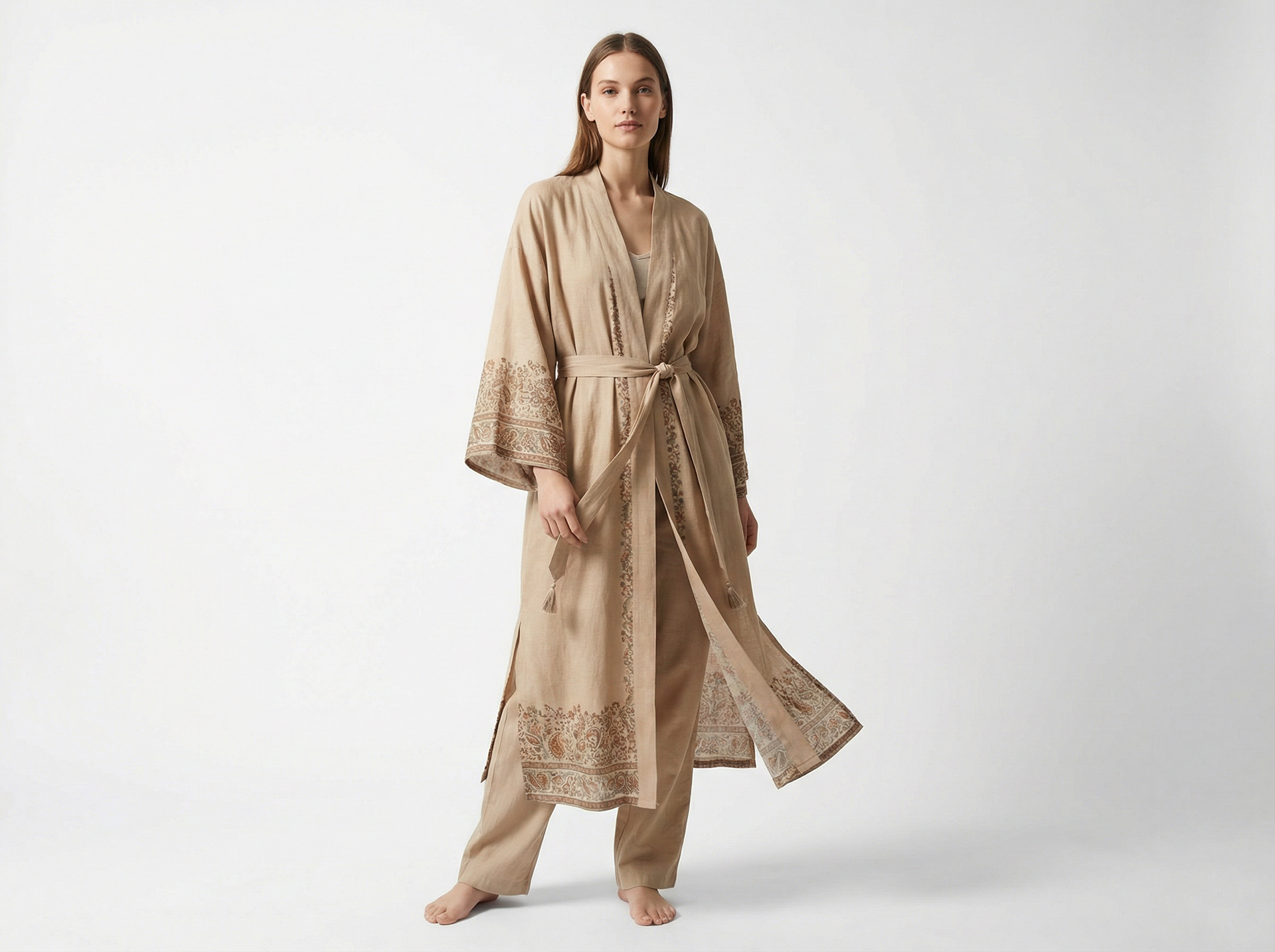 A relaxed, mid-calf robe in breathable linen-viscose with an effortless drape and artisanal finish. The warm sand base is framed with tone-on-tone paisley and ditsy floral border detailing along the cuffs and hem, giving it a refined scarf-inspired look. Designed with wide kimono sleeves and a detachable waist tie, it’s the perfect throw-on layer for slow mornings, travel days, or elevated lounging.