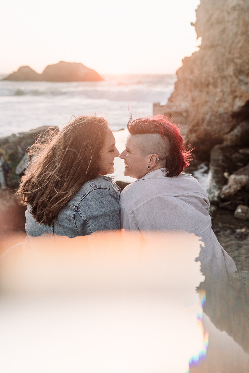 Sunset photograph of two women laughing and kissing.