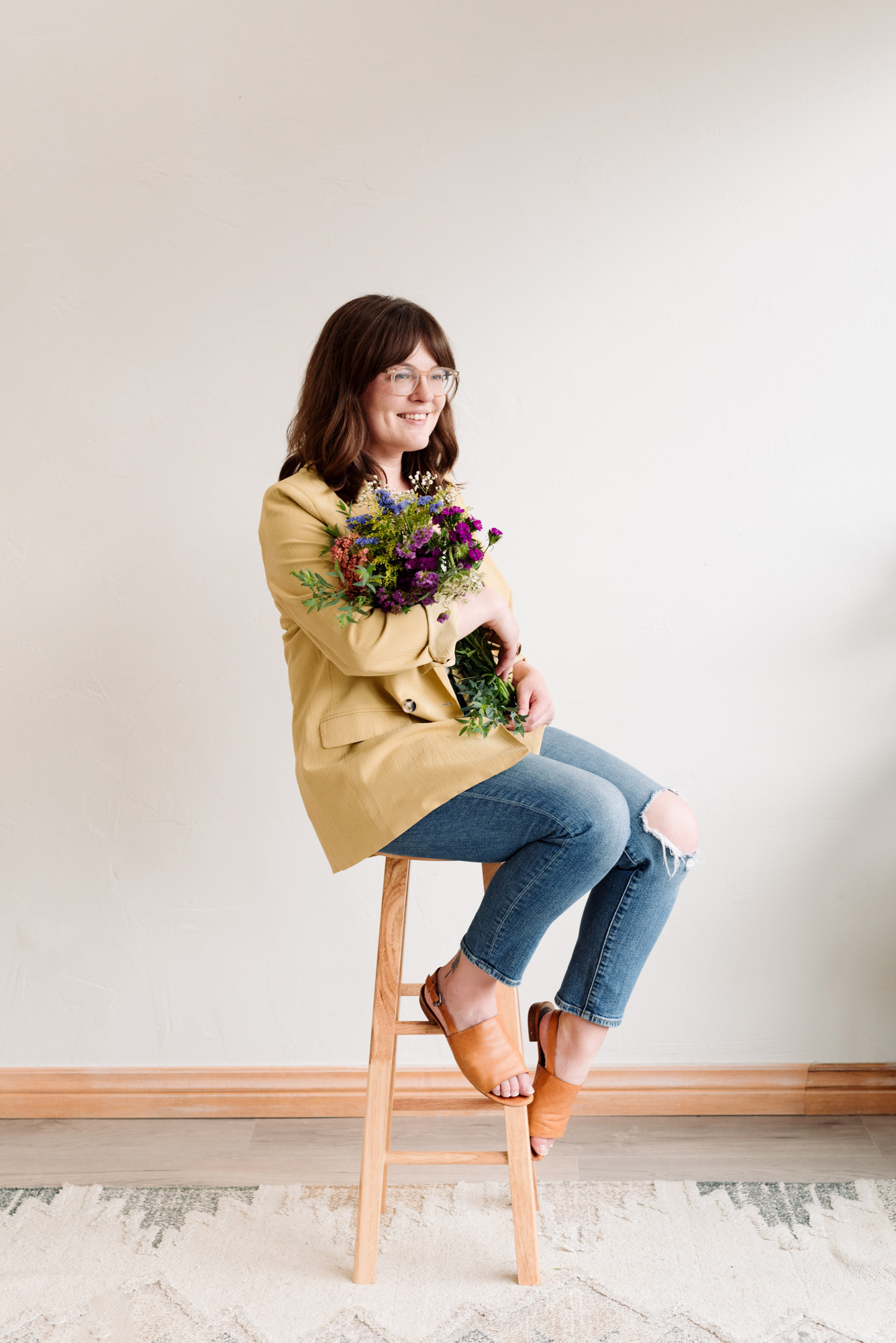 Business branding portrait of a woman in a studio holding flowers.