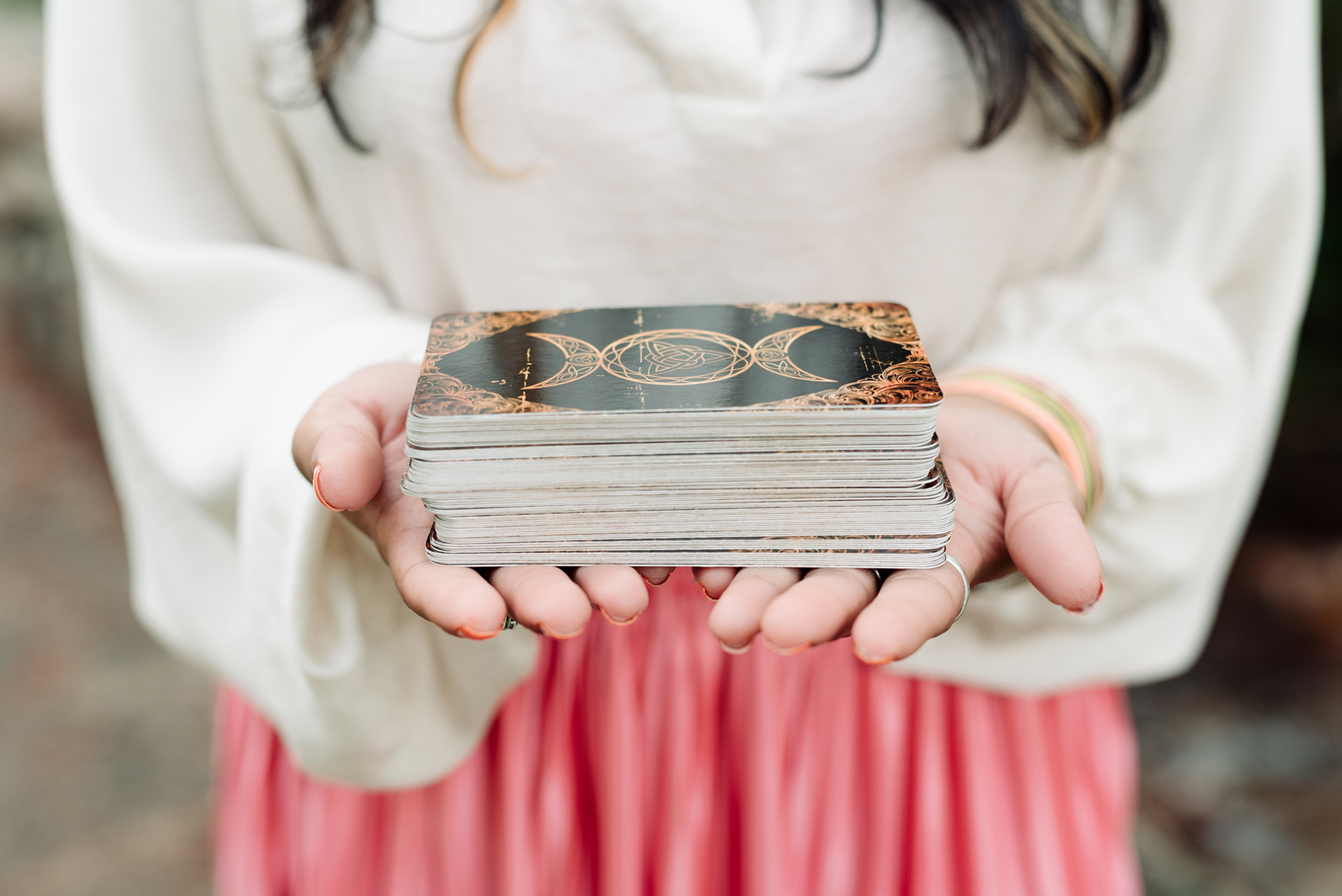 Woman holding a deck of tarot cards.
