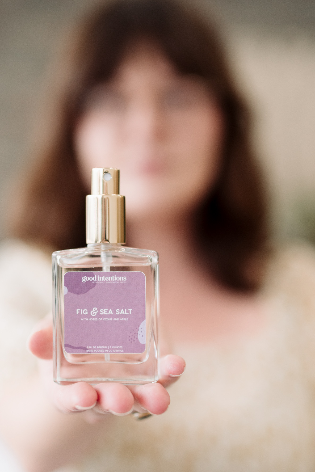 Photo of a woman holding a bottle of perfume for a branding photoshoot.