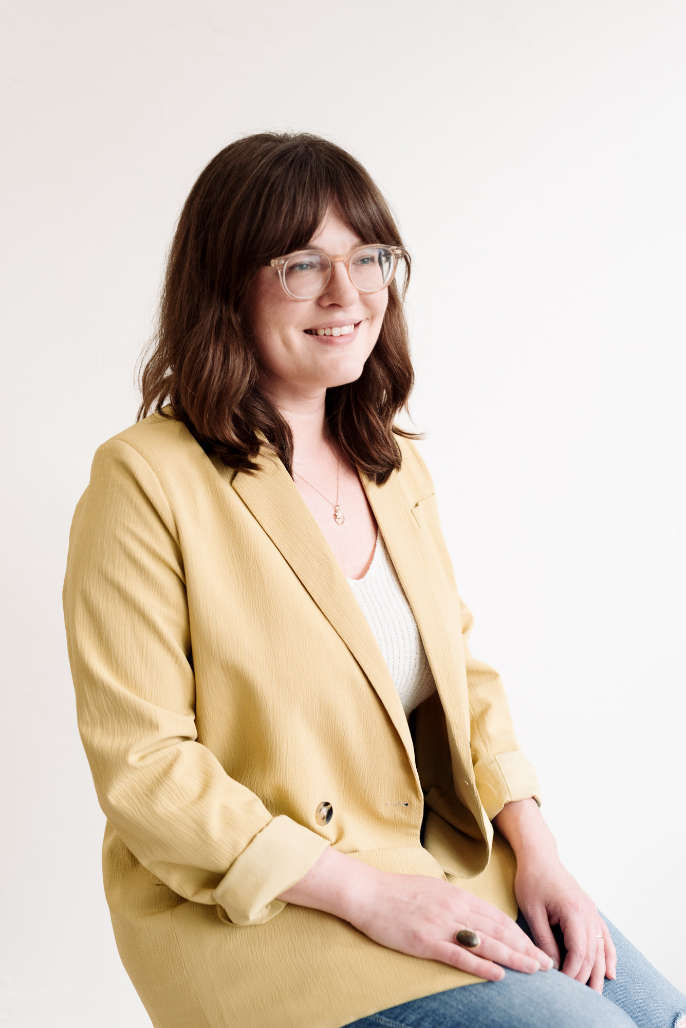 Portrait of a woman in a yellow jacket for her business branding photoshoot.