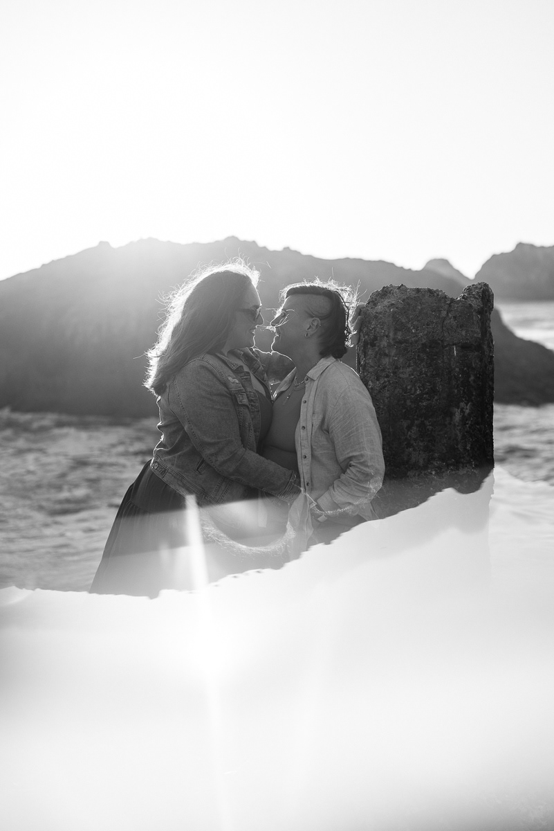 Black and white portrait of two women embracing with a reflection.