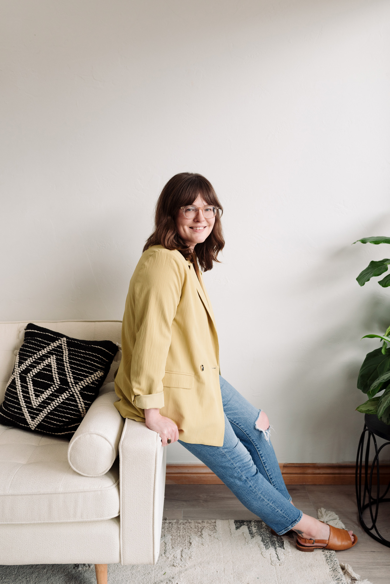 Portrait of a woman leaning against the arm of a sofa for business branding.