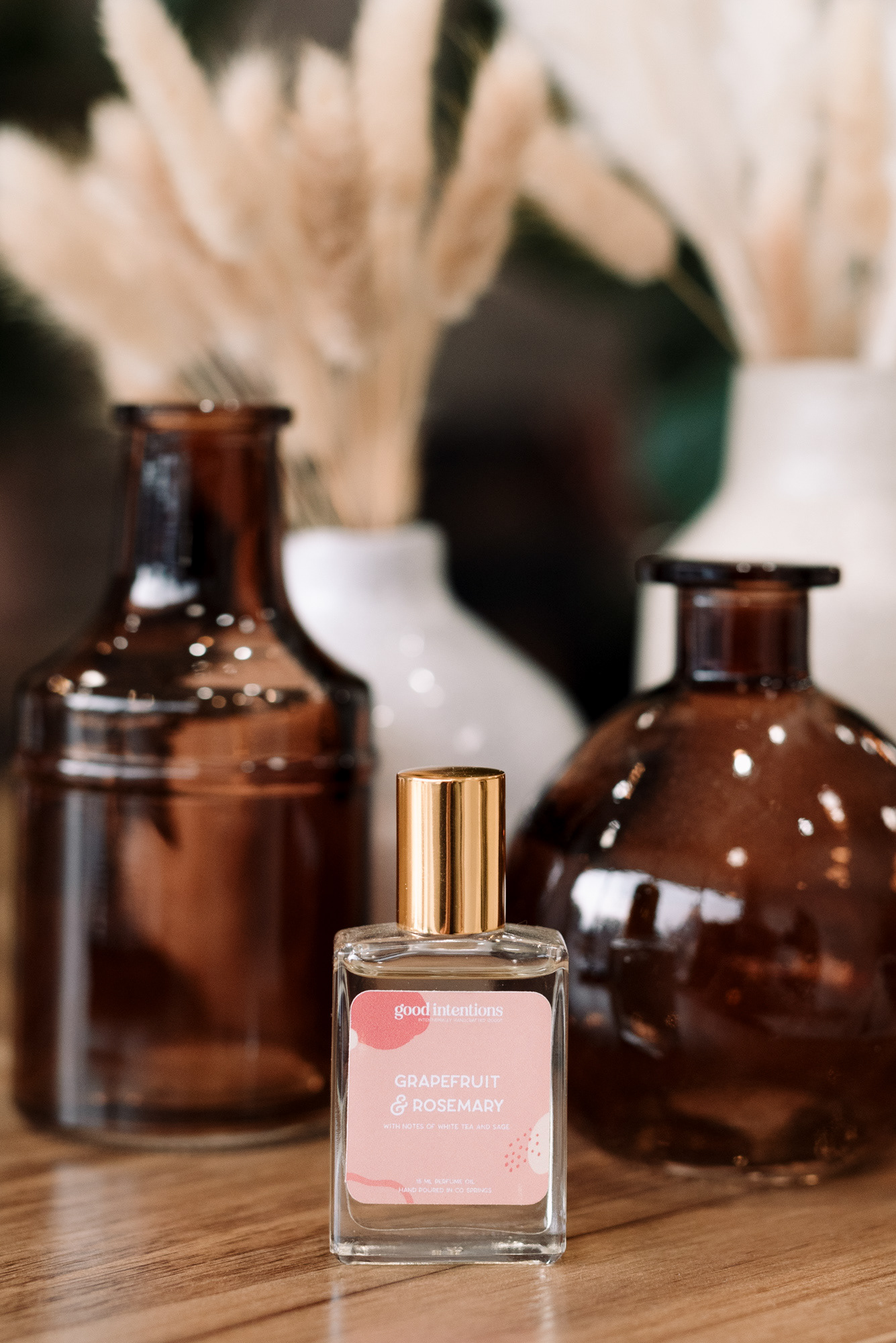 Still life photograph of a perfume bottle and amber bottles.