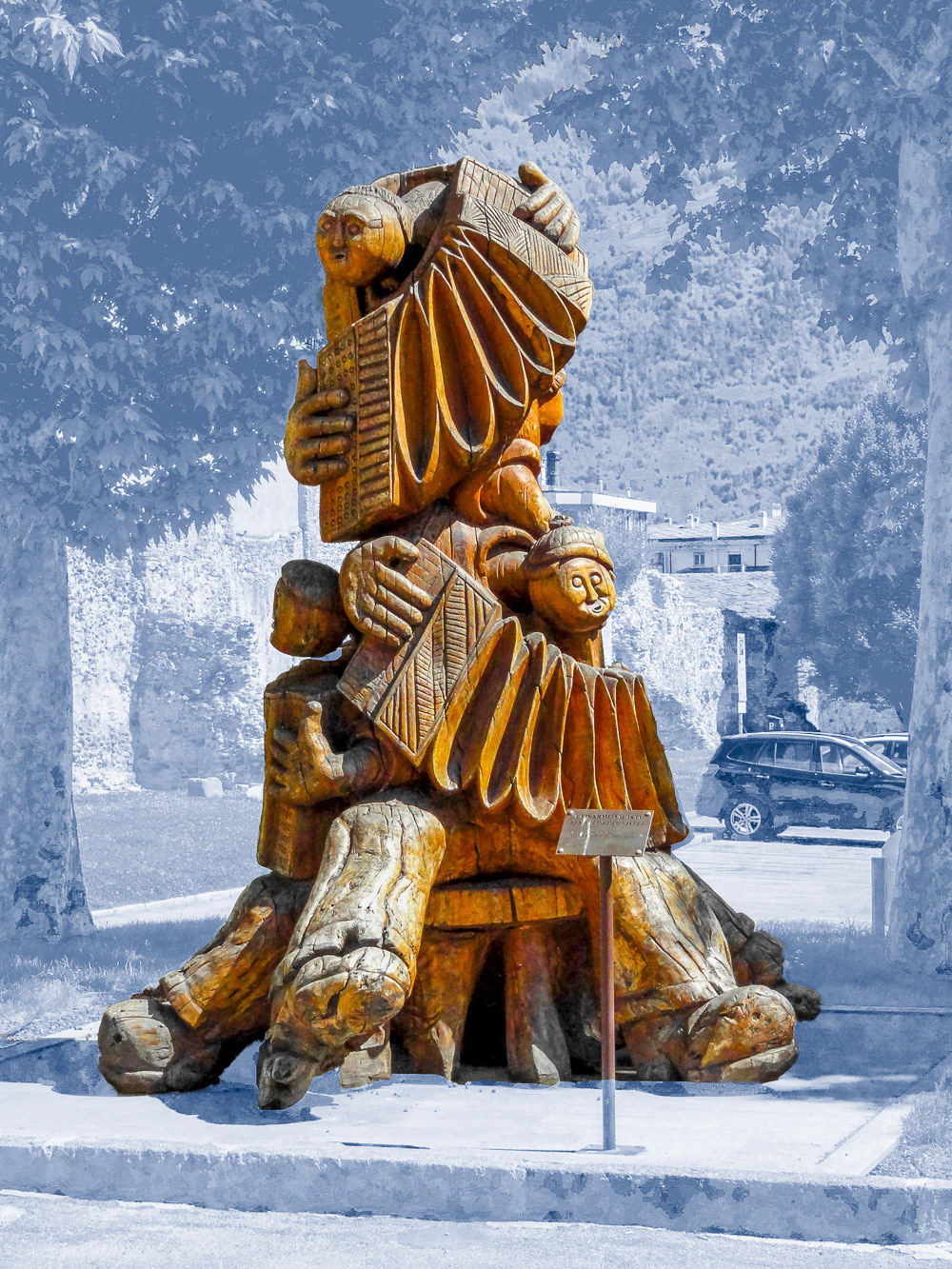 Music in the Park - Wooden sculpture "The Accordionists" by the local artist Dorino Ouvrier in Porta Pretoria square, next to the Roman era city gate, Aosta, Italy