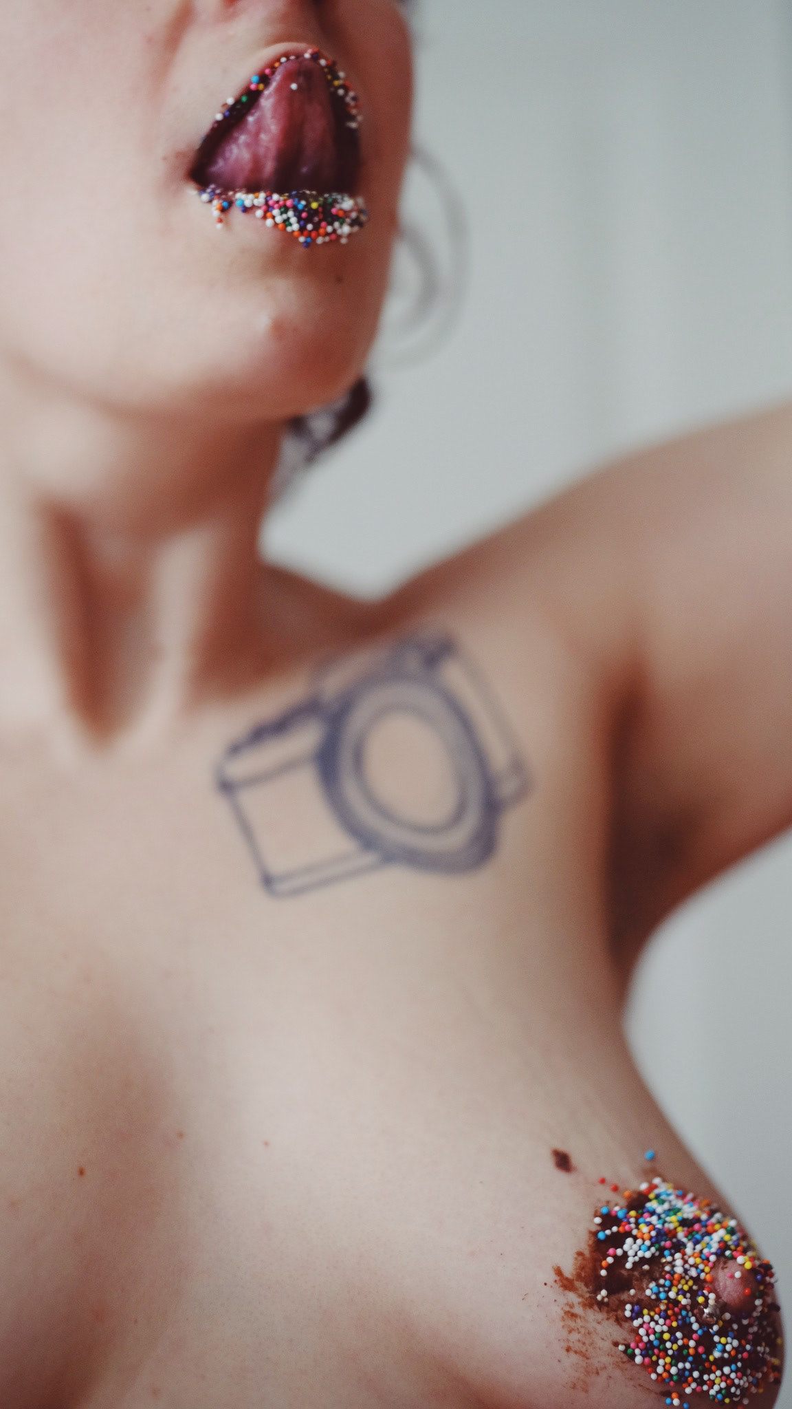 Image description: Sami was licked up her lips covered with chocolate and sparkles. She was topless and there was a nipple covered with chocolate and sparkles.