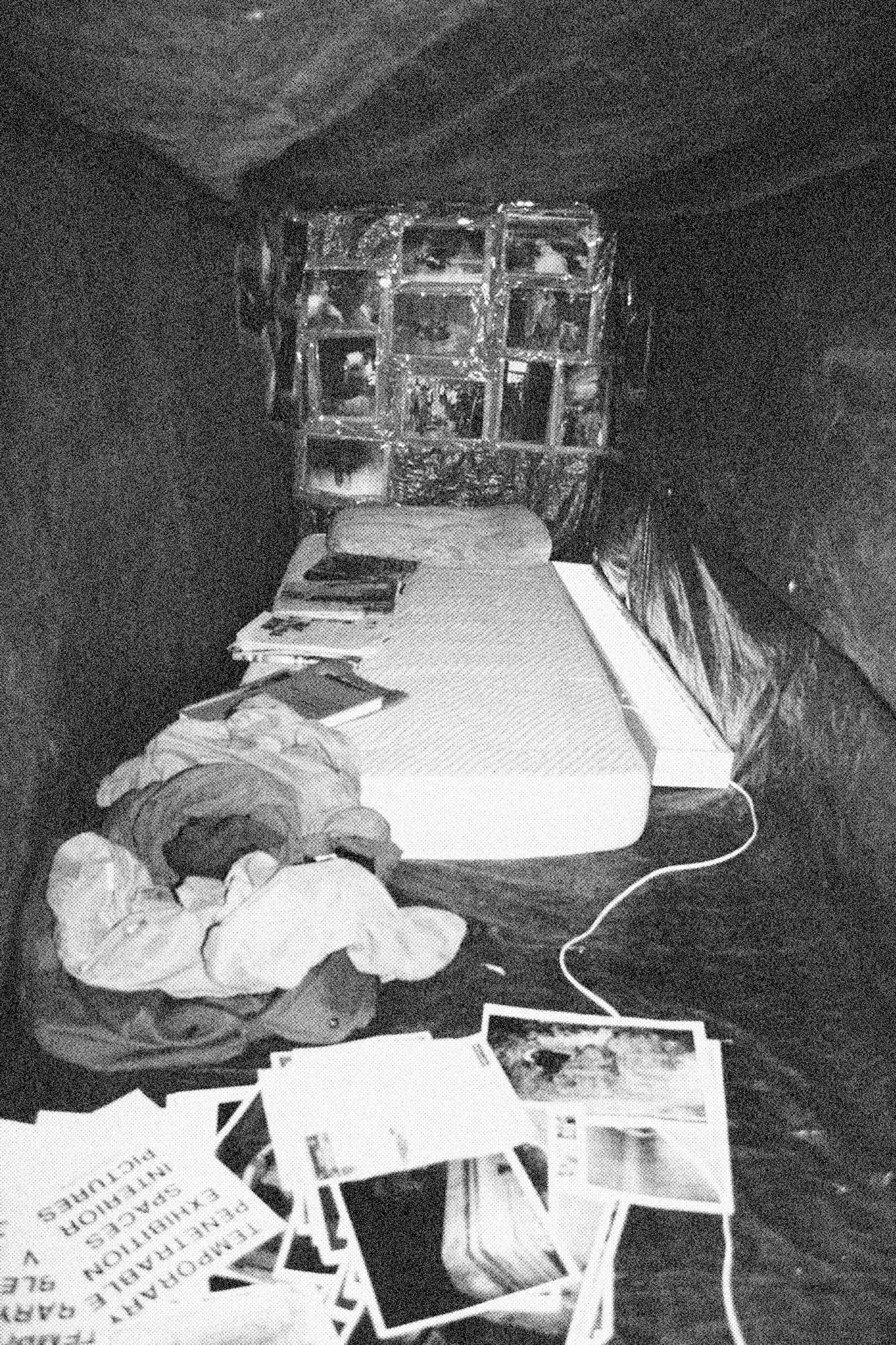 Reconstructed Constructioninstallationcardboard on wooden construction, silk screened wallpaper, tiled floor, carpet floor, electrical equipment: television, DVD-player, transmitter, lightning, plastic ridge tent, silkscreen materials, copy prints, iron case, bed mattress, buckets of latex paint.2006