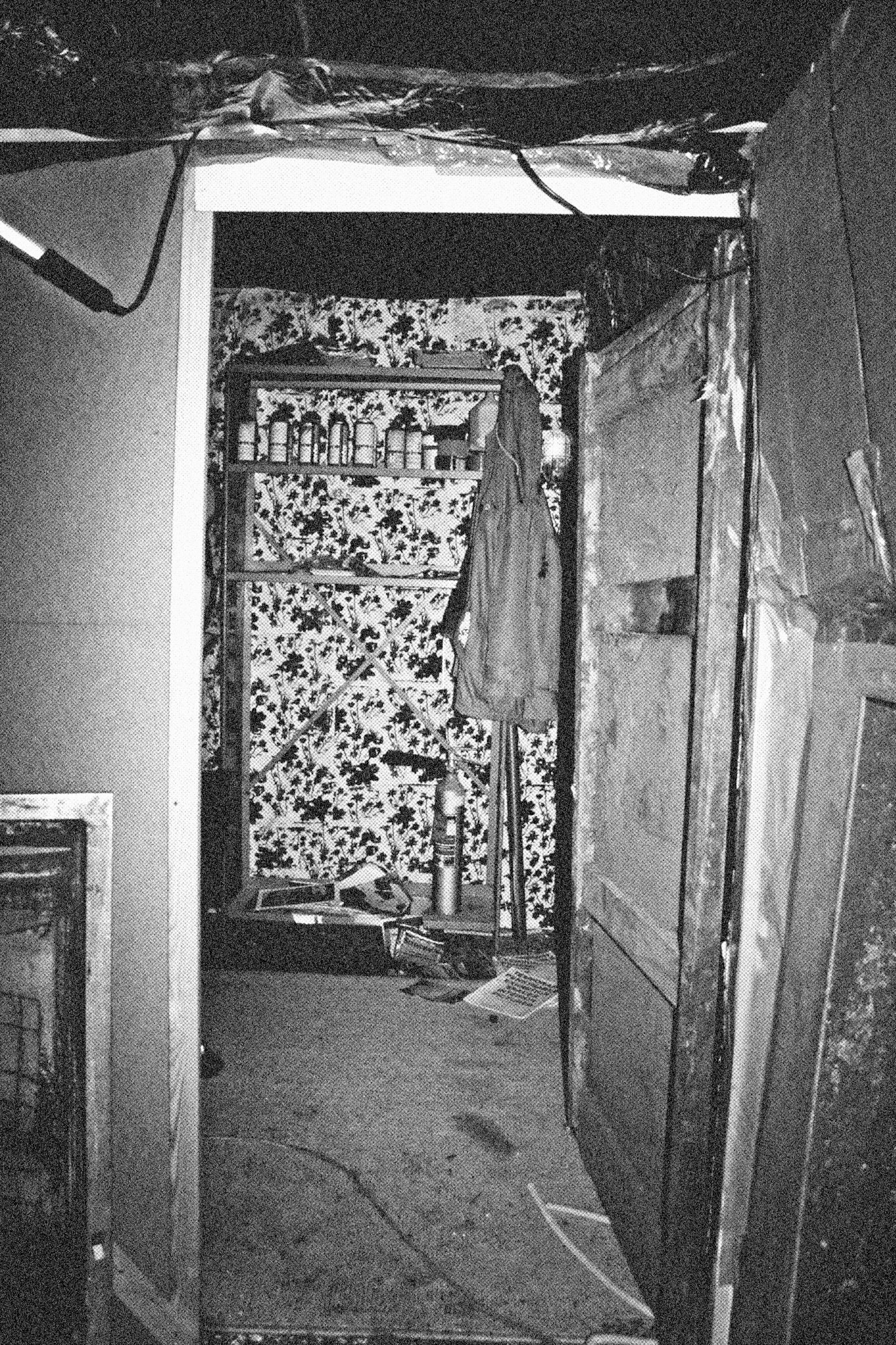 Reconstructed Constructioninstallationcardboard on wooden construction, silk screened wallpaper, tiled floor, carpet floor, electrical equipment: television, DVD-player, transmitter, lightning, plastic ridge tent, silkscreen materials, copy prints, iron case, bed mattress, buckets of latex paint.2006