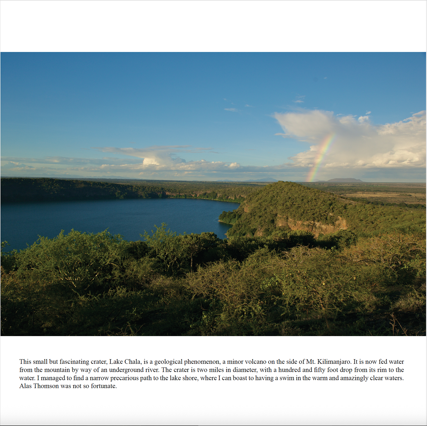 Lake Chala, a crater lake on the slopes of Mount Kilimanjaro, with a rainbow over the surrounding bush, Through Maasailand.