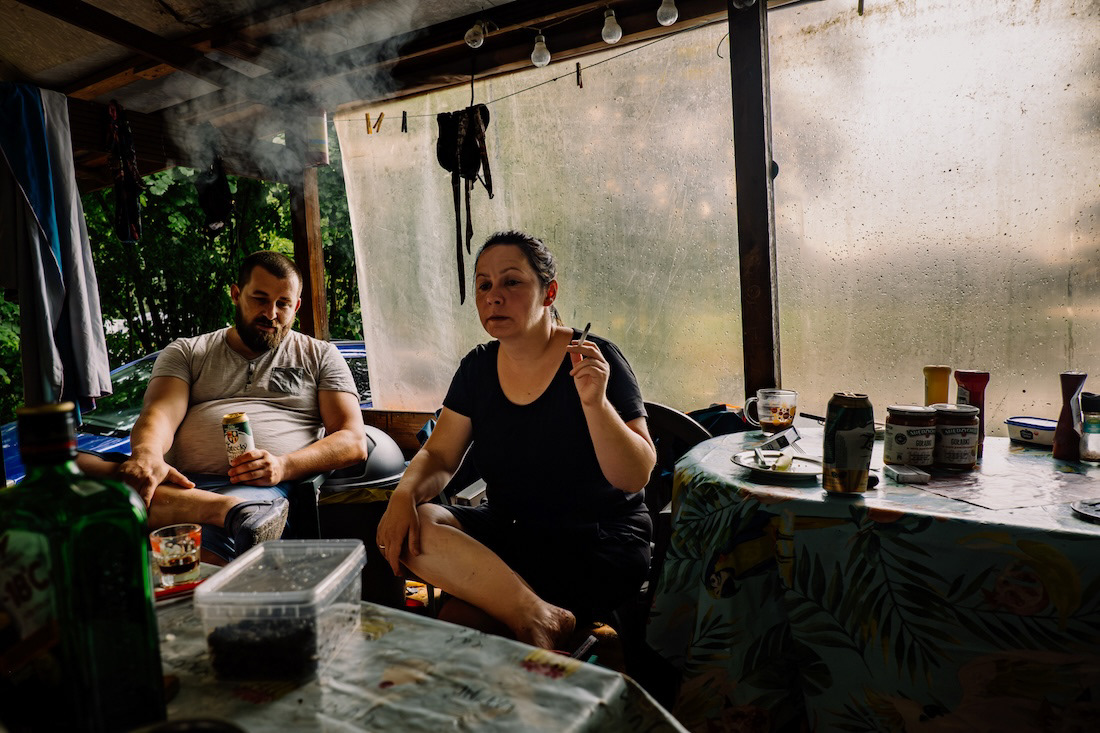 Couple sitting at a table inside a summer campsite shelter, from the project Only in Summer