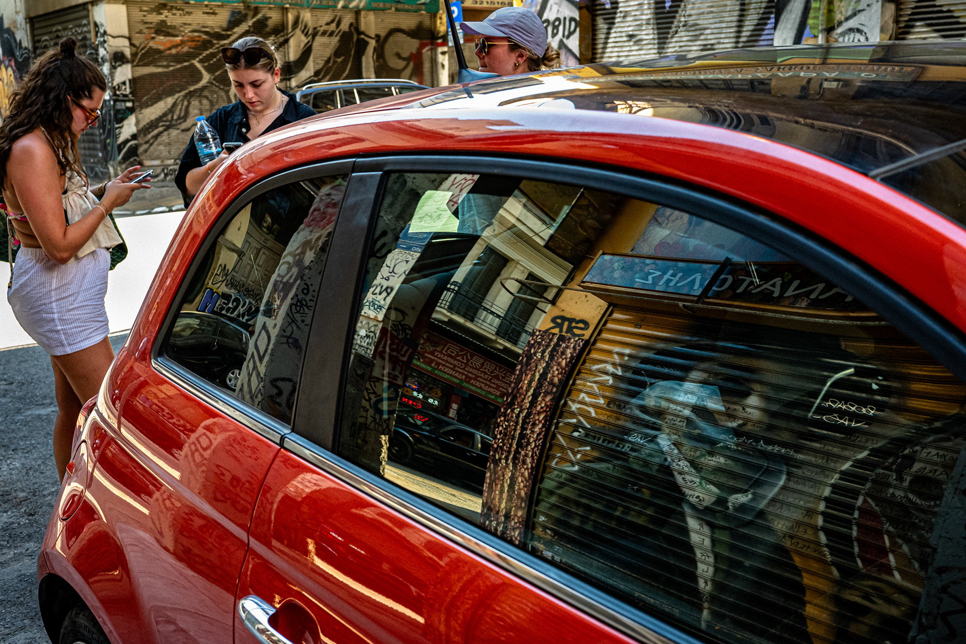 Red car with city reflections in the window