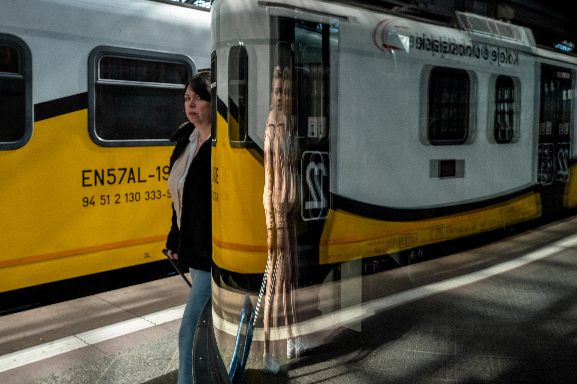 Woman standing next to a train on a railway platform