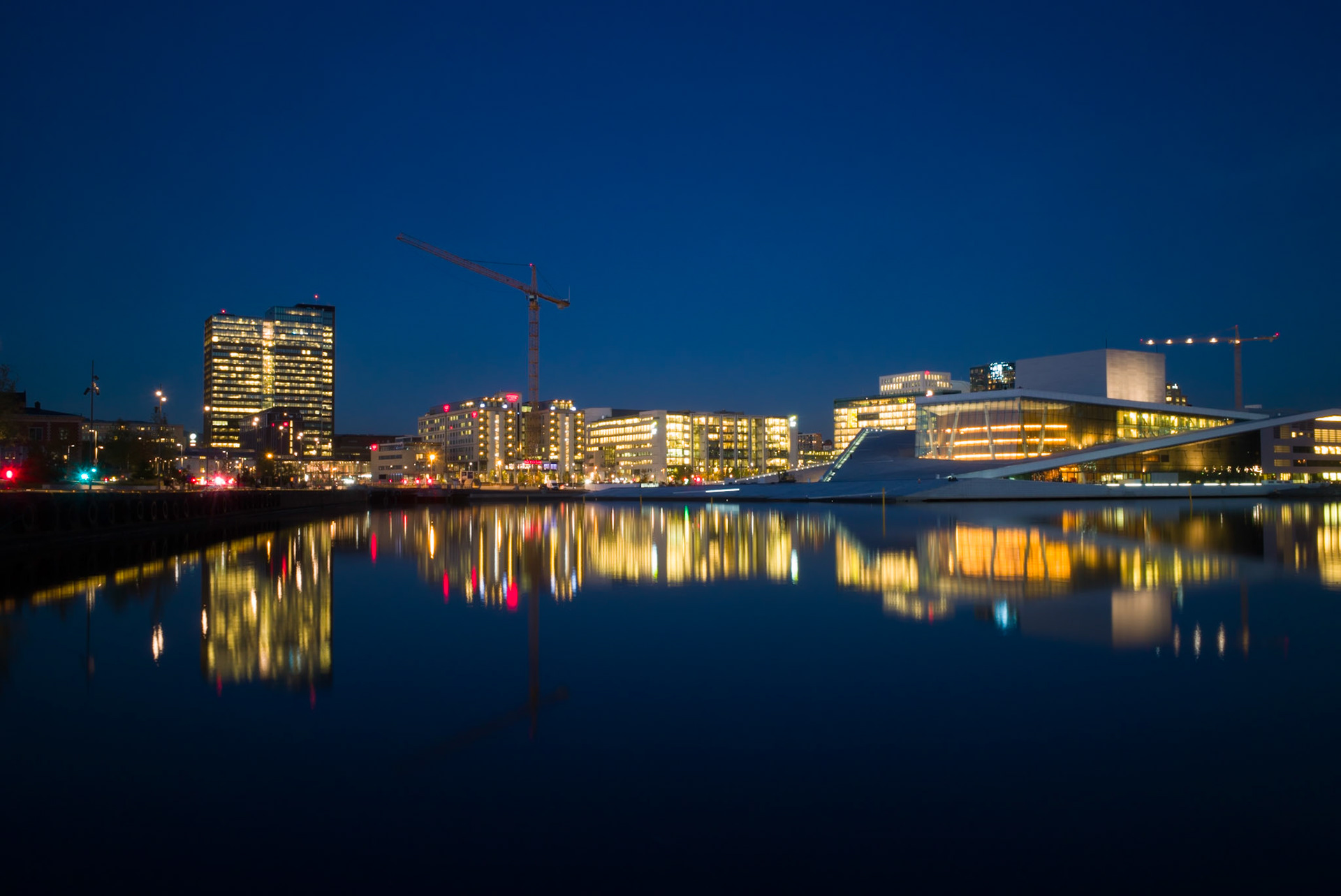 Lights from Oslo Opera House and Oslo center reflected in the water.