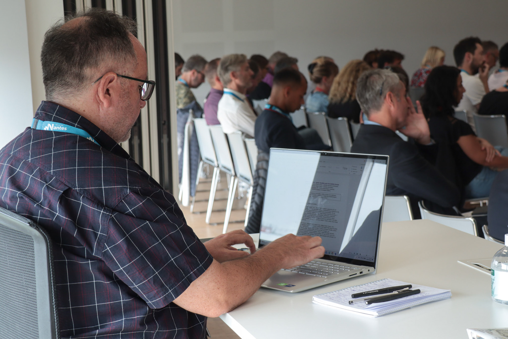 Les rédacteurs, dans le fond des différentes salles sont bénévoles. Plusieurs conférences se déroulent en même temps. Pas de panique, à la sortie du FIL, les participants ont des résumés de chaque conférence. 