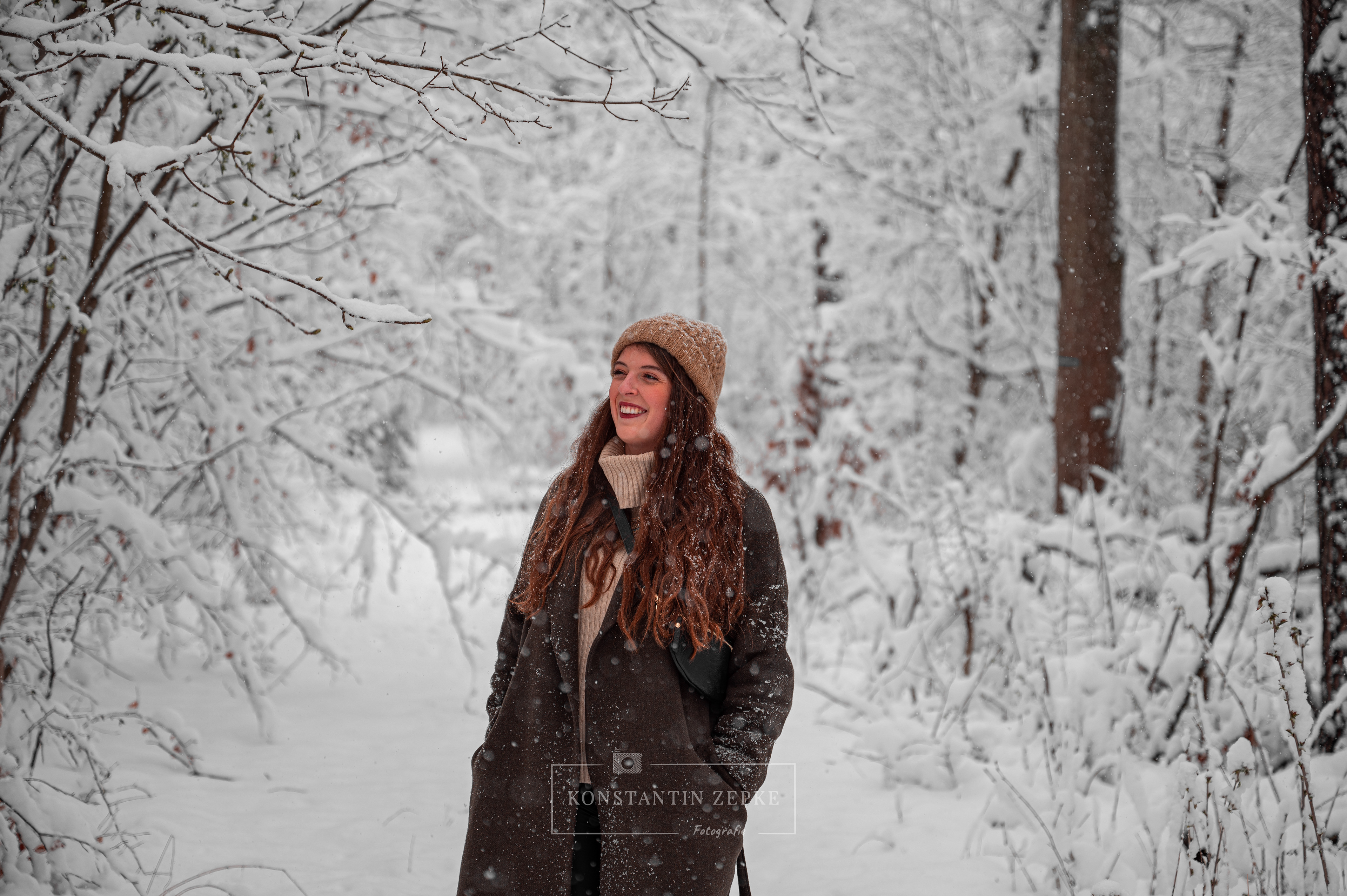 Natürliches Winterporträt einer Frau im Schnee